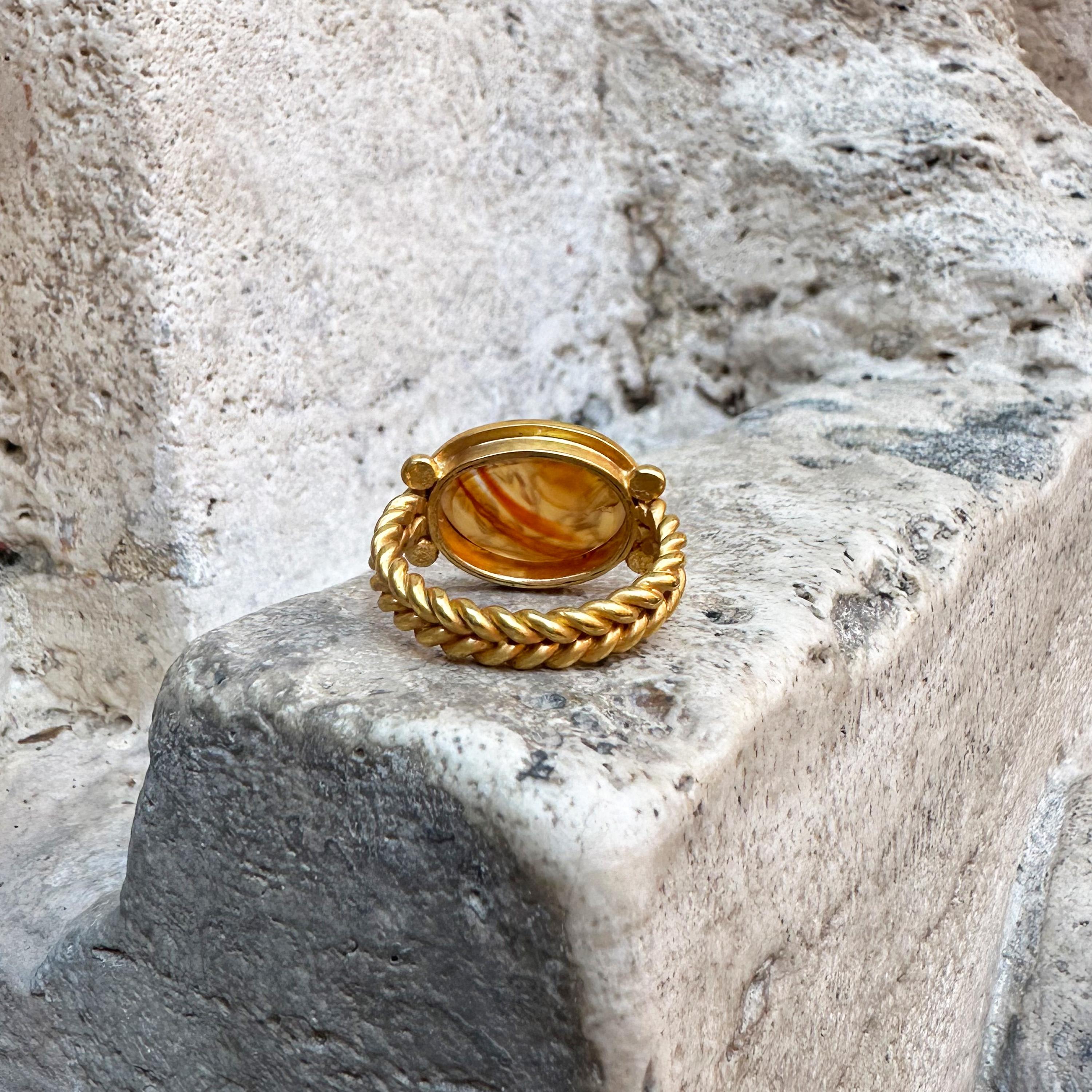 In this 18 kt gold ring, handmade by our goldsmiths, an authentic Roman carnelian intaglio depicting a winged Eros/Cupid standing on a a chariot pulled by two roosters.

Eros, the god of Love, known as Cupid by the Romans, has always been depicted,