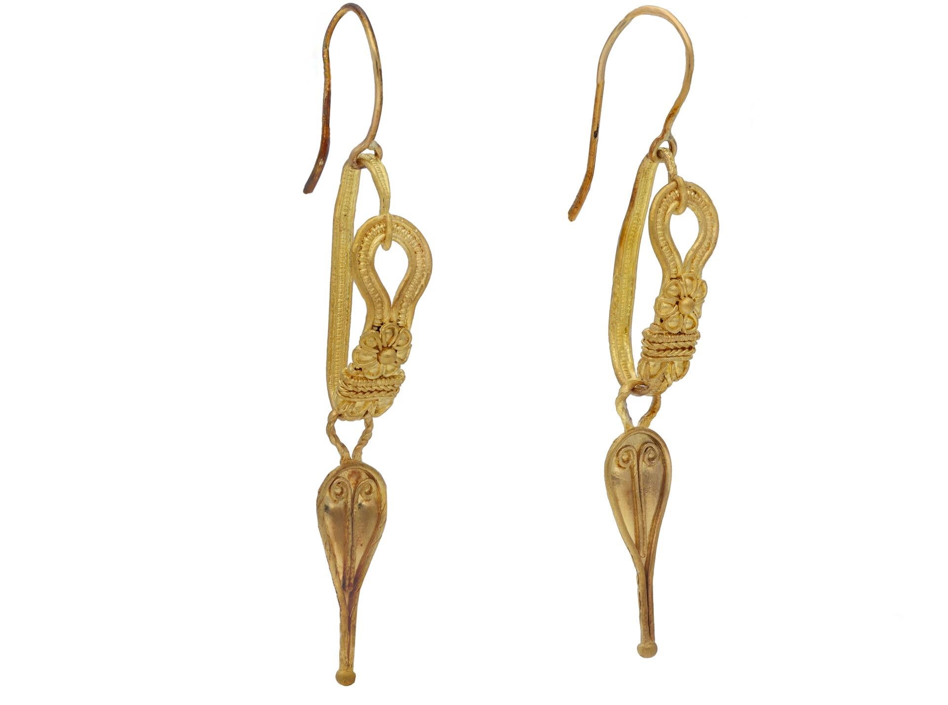 Ancient Roman earrings, 2nd century AD. A pair of yellow gold earrings, each with an inverted drop shaped ornament decorated a gold bead and scrolled wire ornaments and borders, each on a twisted wire loop, suspended from an ornate open looped hook