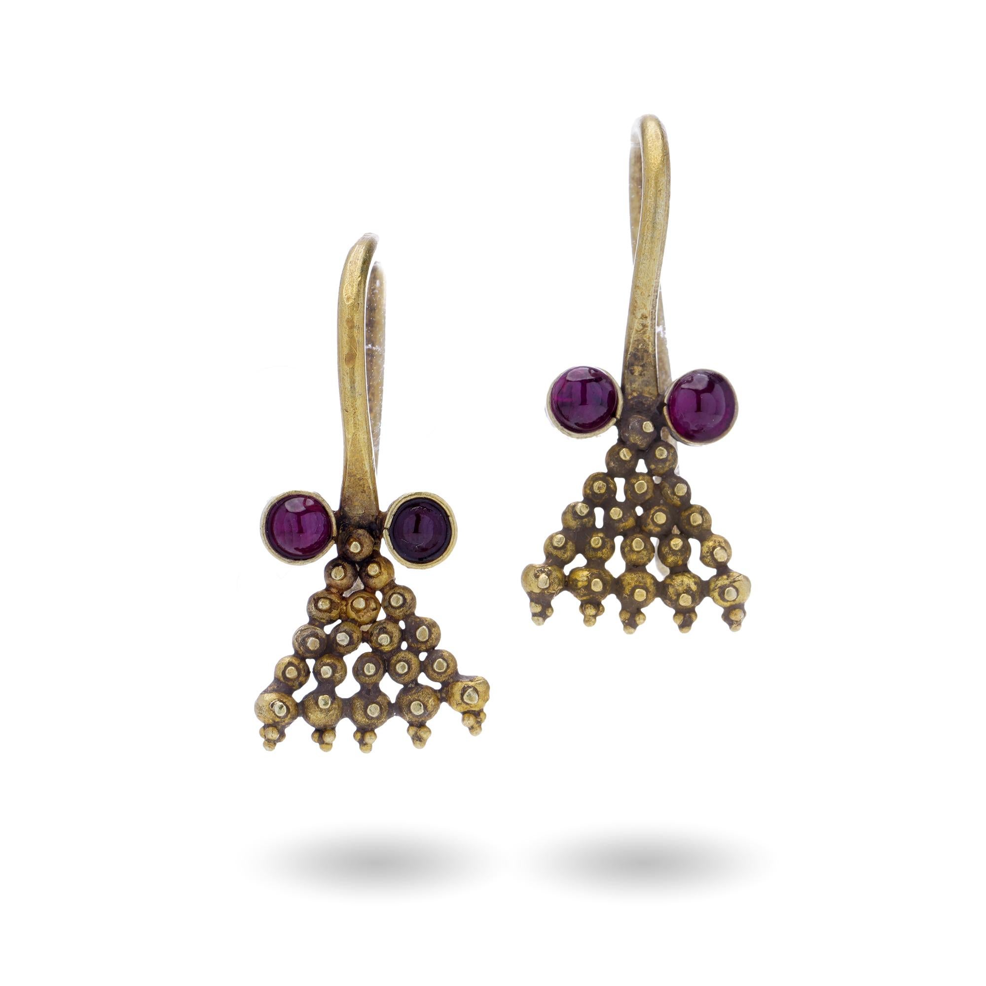 Ancient Roman Empire 3rd-century 16kt yellow gold earrings set with cabochon-cut rubies.

Design and Pattern:
Shape: The earrings are hoop-like with a distinctive granulation technique, where tiny gold beads are applied to form clusters.

Motif: The