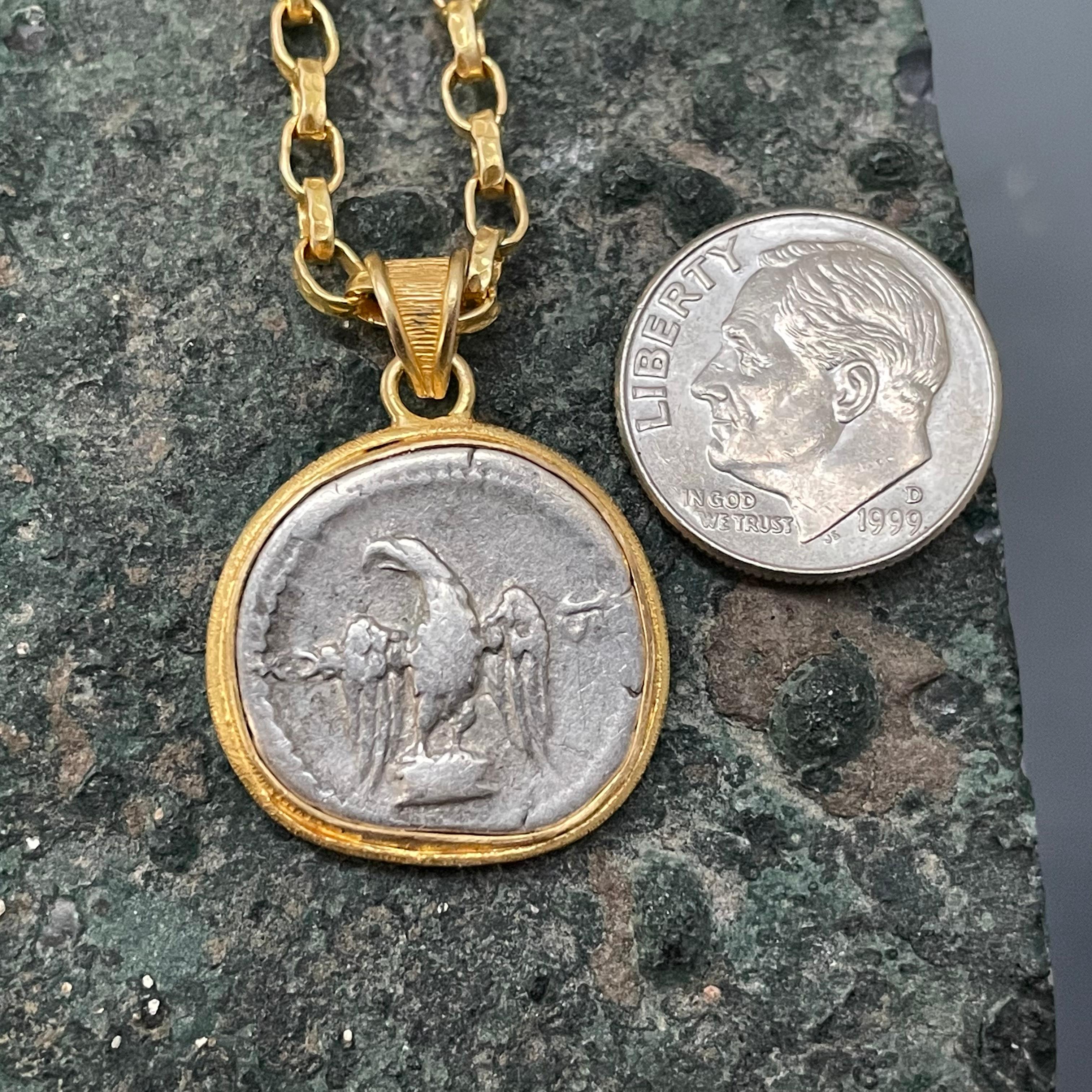 An authentic silver denarius coin with a depiction of the Roman Imperial eagle standing, minted during the realm of the emperor Vespasian in 69-79 AD, is set in a simple matte-finish line textured handmade bezel designed by Steven Battelle.  The