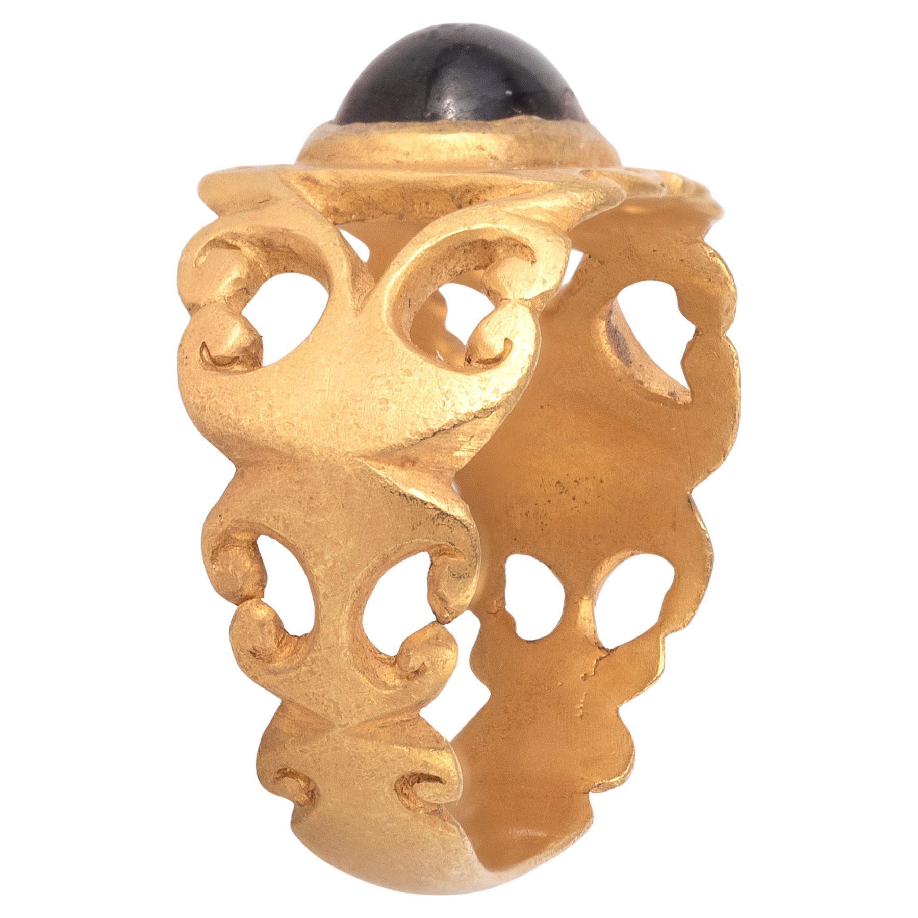 Si tratta di un antico anello romano da dito in oro, risalente al III secolo d.C. L'anello è di buone dimensioni, con un castone rotondo in rilievo con una gemma di granato incastonata. L'anello da dito può risalire al III secolo ADS. L'anello da