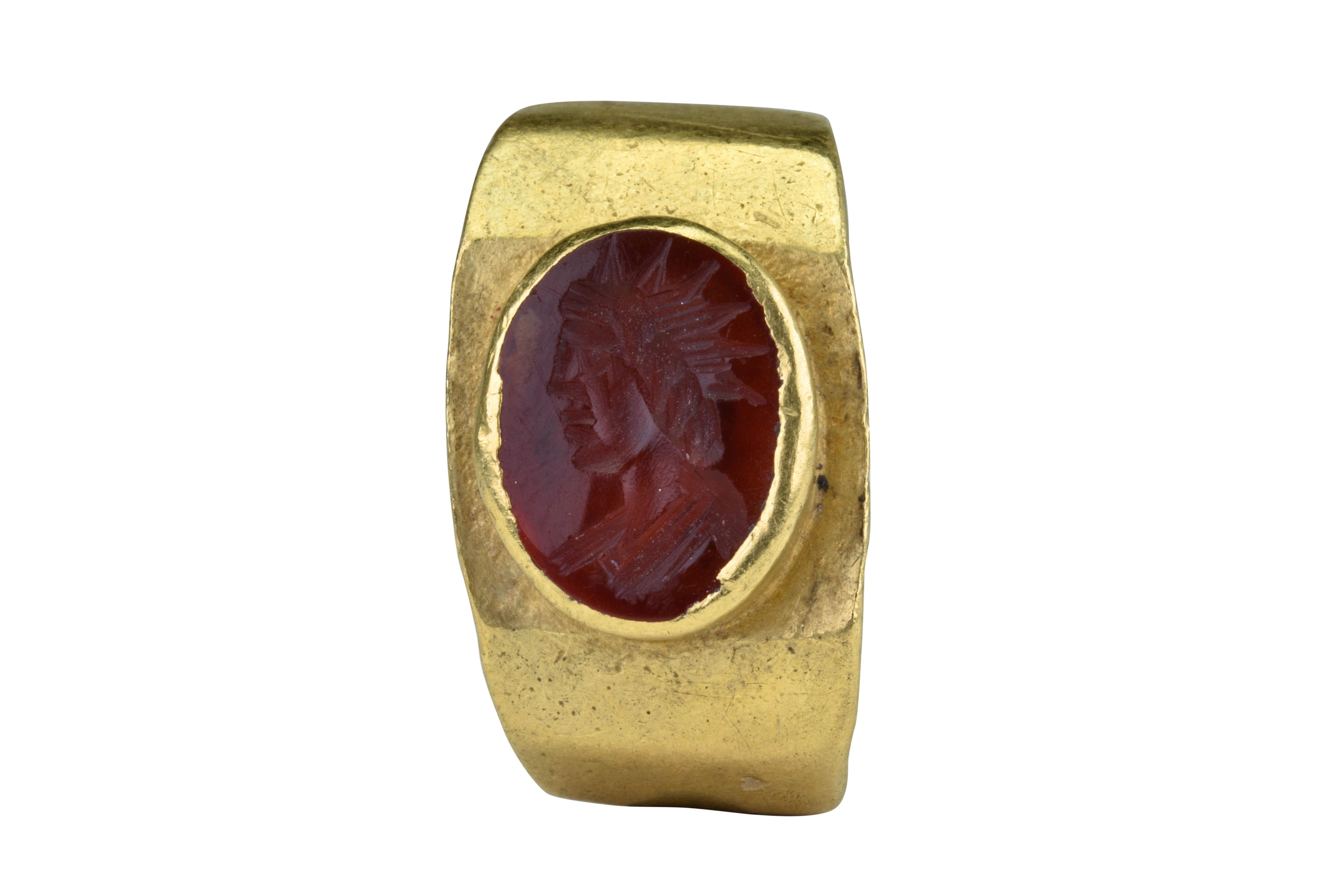 Ancient Roman Gold Intaglio Signet Ring with Sol Invictus

Ca. 200-300 AD

An Ancient Roman gold ring of faceted, flat-section band tapered to the rear. Bezel containing a stone intaglio depicting the bust of Sol Invictus wearing a radiate crown.