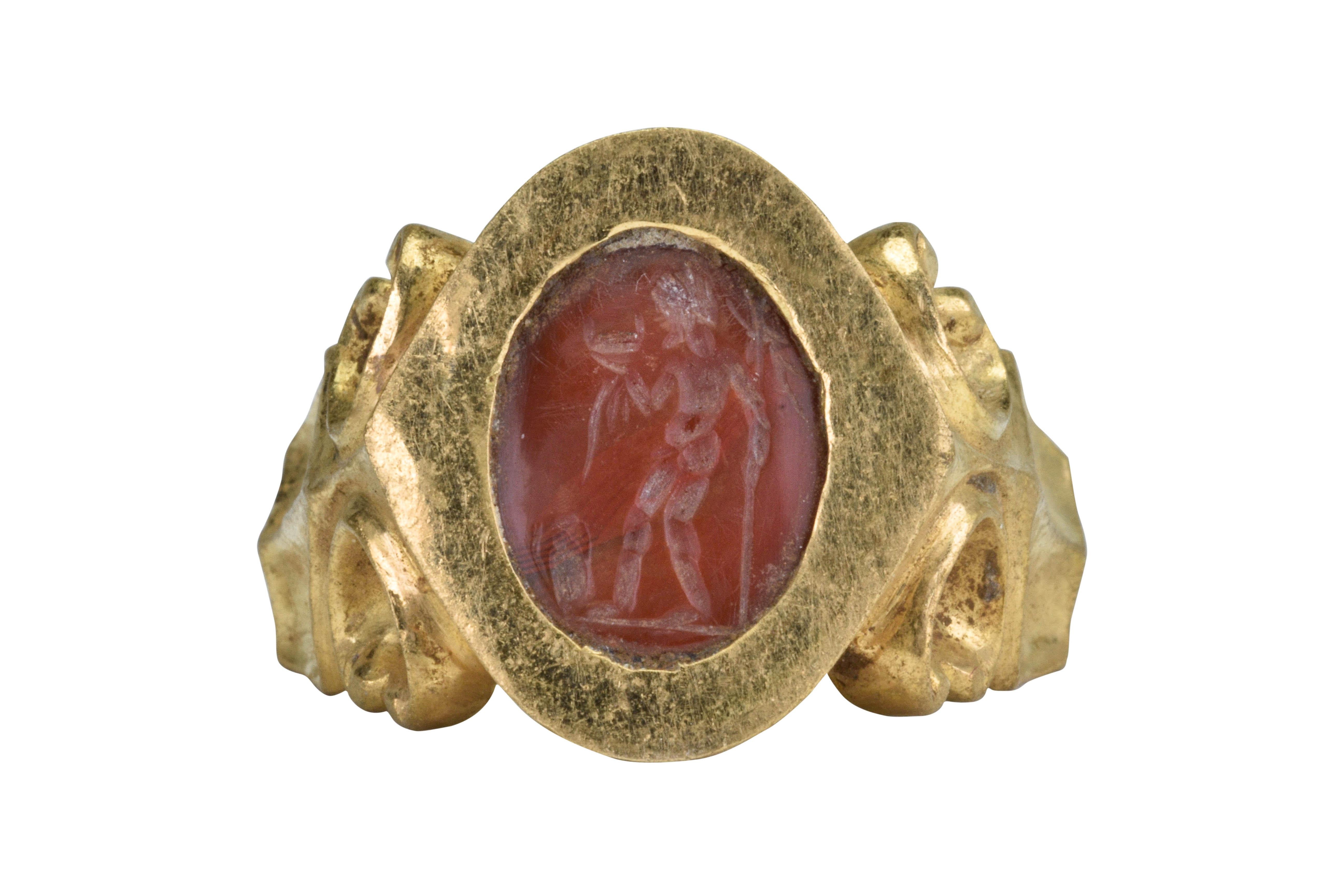 Ancient Roman Gold Intaglio Signet Ring with Standing Goddess

Ca. 100-300 AD

 An Ancient Roman gold ring of a round hoop flaring towards shoulders, intricately decorated with scrolls. A bezel set with a carnelian intaglio engraved with a nude,