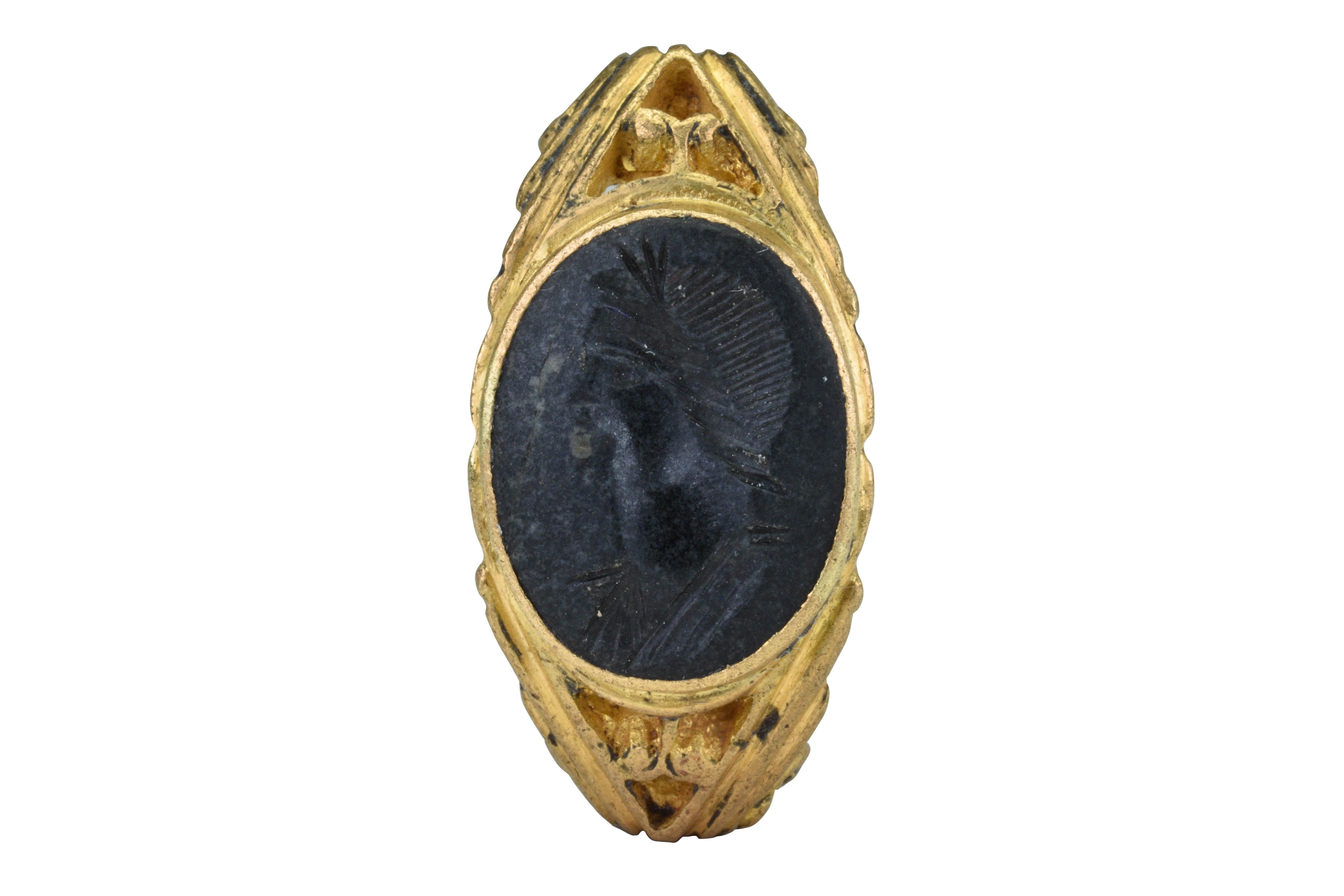 Ancient Roman Gold Portrait Intaglio Signet Ring

Ca. 100-300 AD

An Ancient Roman gold signet ring with a D-shaped hoop embellished with scrolling acanthus leaf ornamentation leading to expanded open-work shoulders with two pairs of opposed pelta