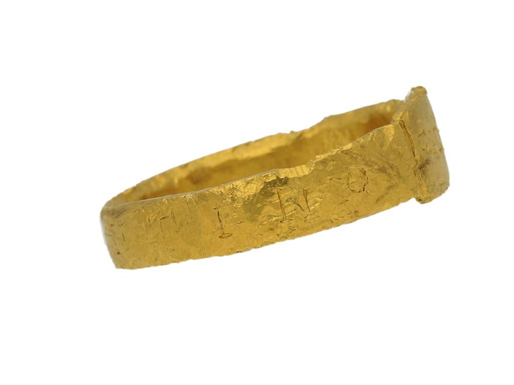 Ancient Roman gold ring. A textured gold band featuring a central rectangular plaque inscribed 'FIDEM', leading to integrated shoulders and flowing through to a gently tapering solid flat shank, inscribed 'CONSTANTINO', both words translating from