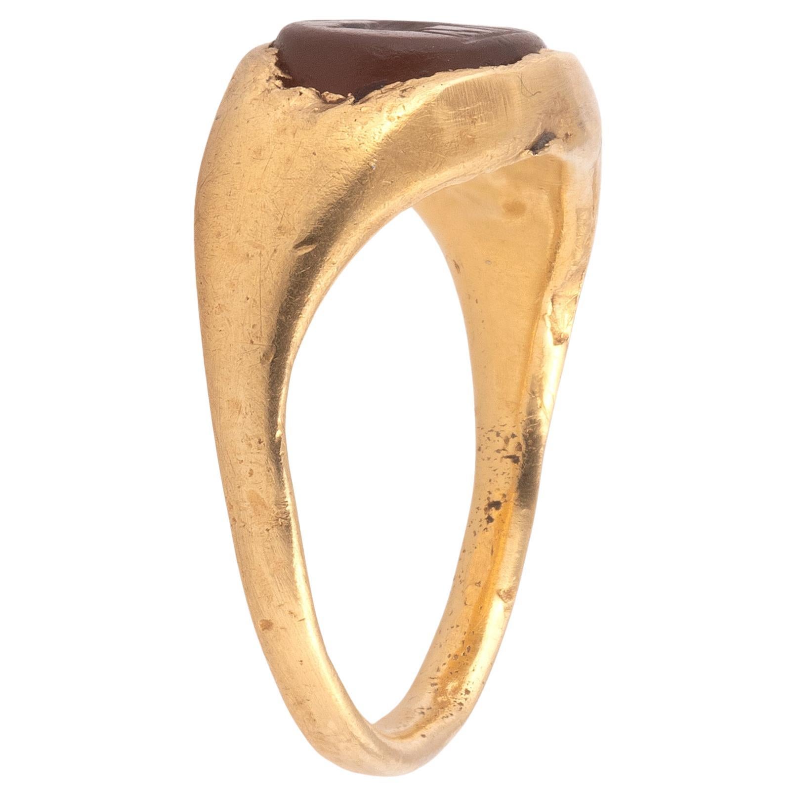 Ring set with an intaglio representing the deer and the cypress
Hollow setting
Gold and carnelian
Roman art, 1st-2nd century
Intaglio size: 0.8 x 0.6 cm
Ring size: 6
Weight: 5.76 gr

The deer is the symbol of vital regeneration due to the periodic