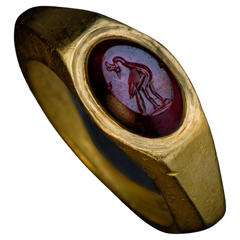 Anello d'oro romano antico con incisione in granato di un pavone