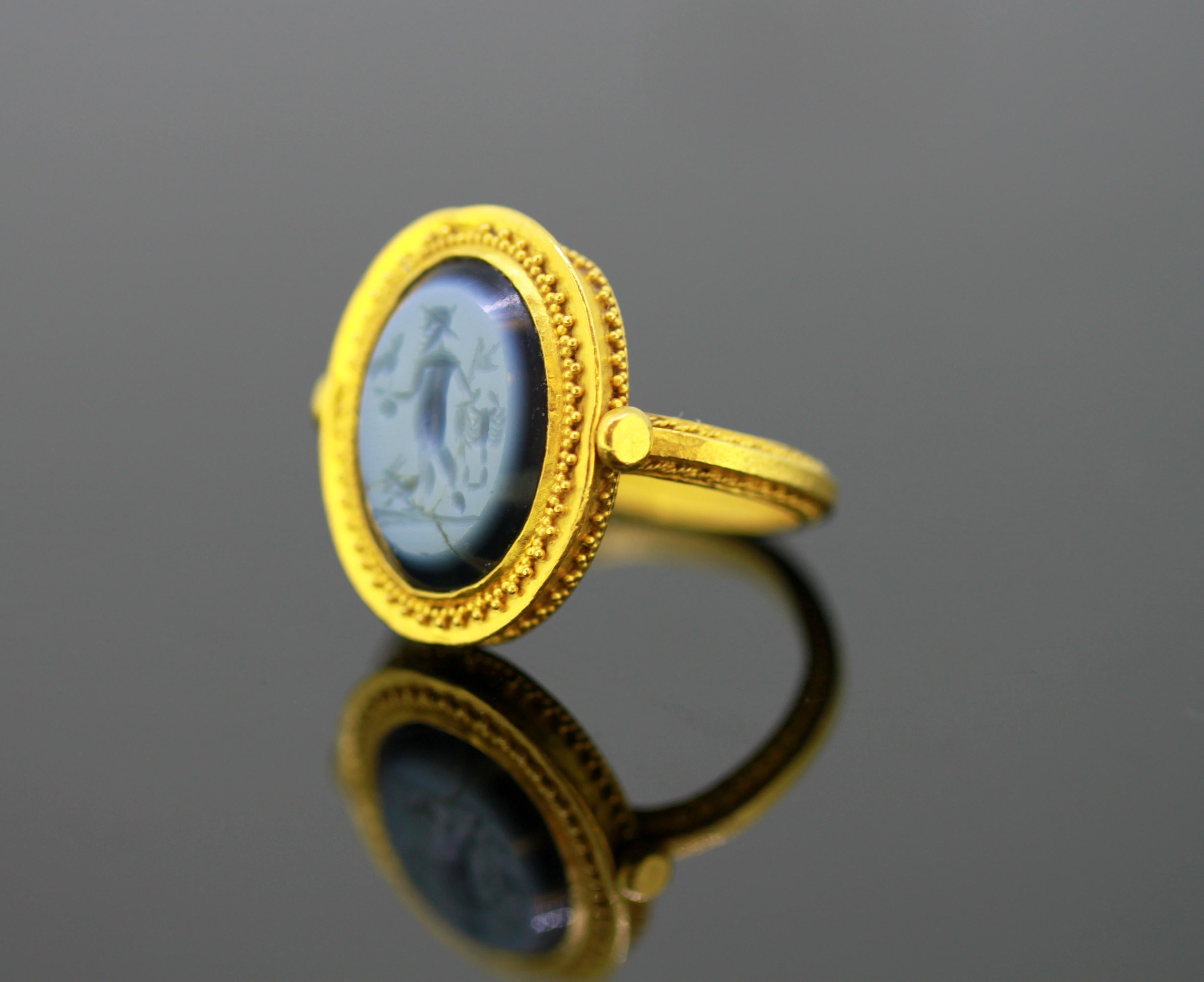 Ancient Roman gold ring with nicolo intgalio, depicting a gladiator, who is holding a scorpion and a bird.

Nicolo is a cameo or intaglio that is carved in onyx in such a way that the image displays a translucent bluish/grey color. This thin top