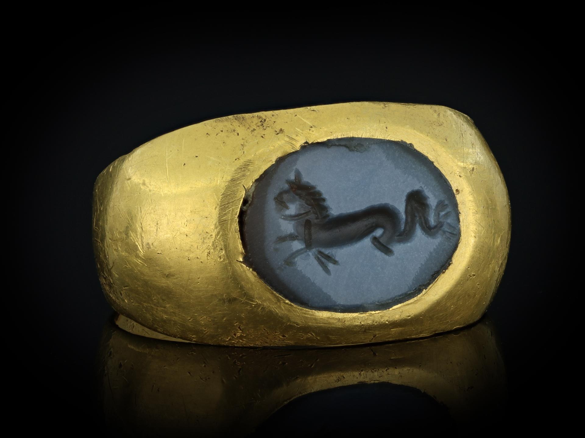 Ancient Roman Hippocampus intaglio ring. Set with an oval nicolo onyx intaglio depicting a hippocampus facing left, in a closed back roman-set setting, flanked by broad integrated shoulders and flowing through to a solid flat shank. Tested yellow