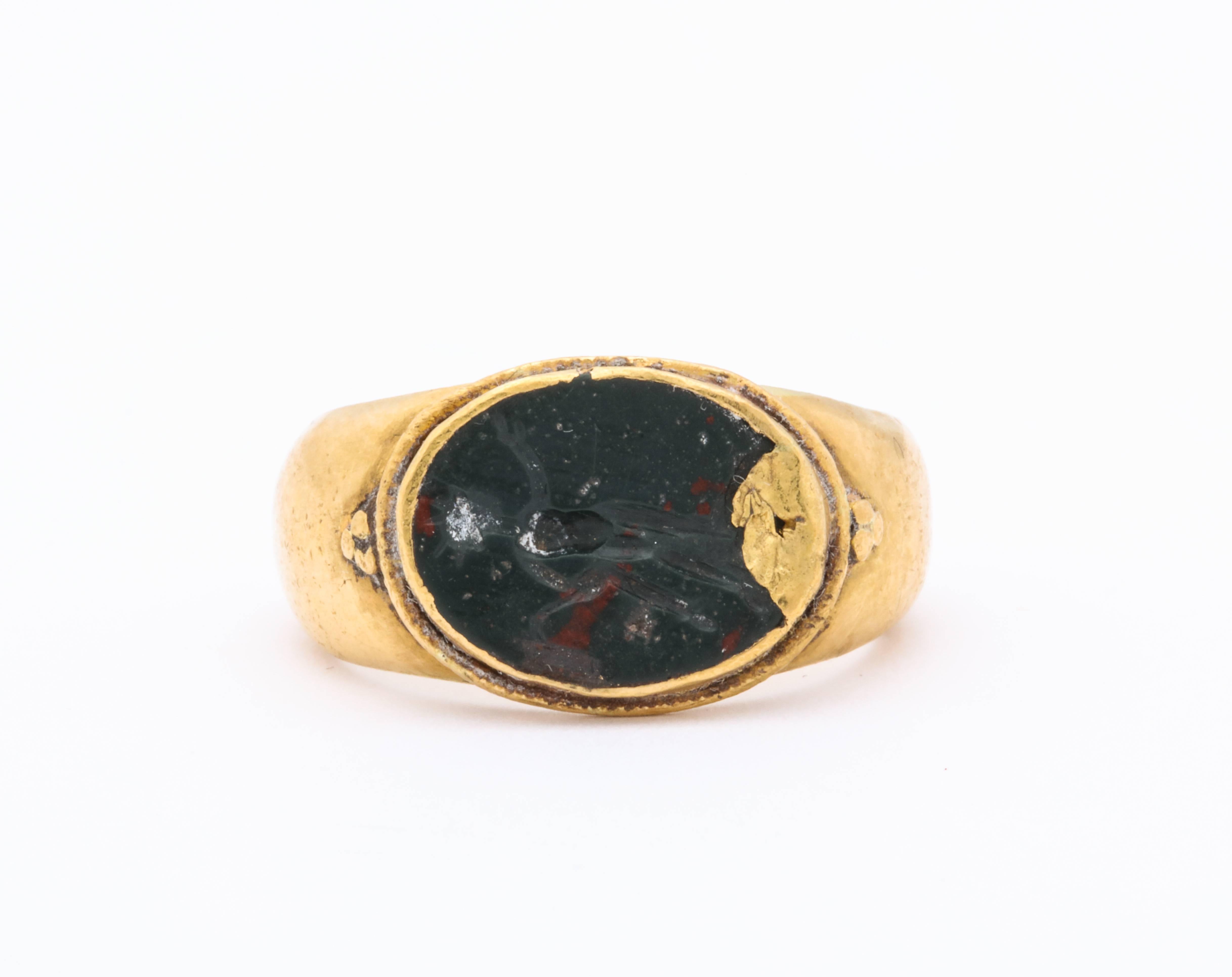 A remarkable and original ancient Roman ring c. 3rd or 4th century A.D. is set with a heliotrope intaglio showing Helios, God of the Sun tests at least 18 Kt gold. Helios holds a whip with which to drive his horses and wears his Crown of the Sun and
