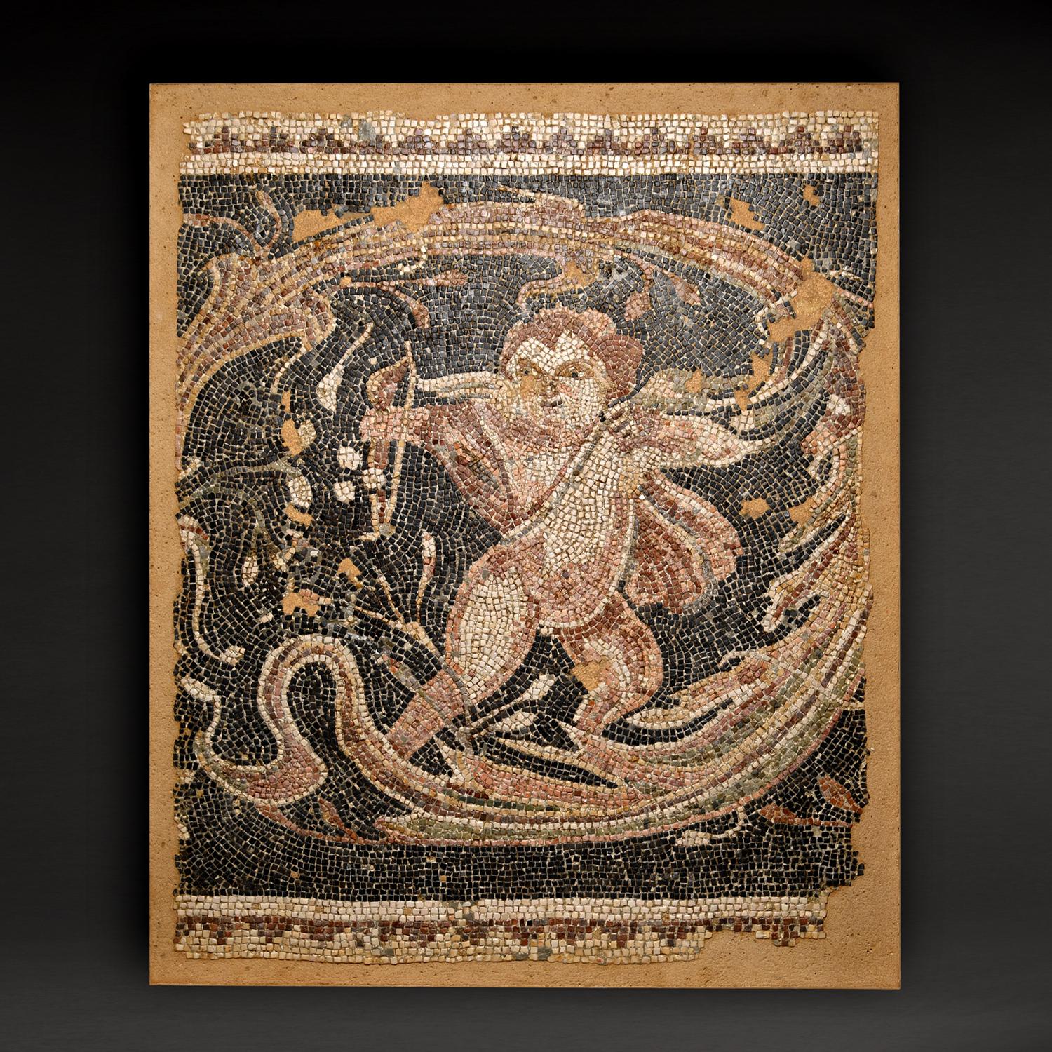 Questo superbo mosaico di marmo è un originale romano del III-IV secolo ADS.  L'immagine raffigura un Eros alato, con un mantello svolazzante, che tiene l'arco nel braccio destro teso e una faretra legata al busto. An He è appoggiato all'indietro