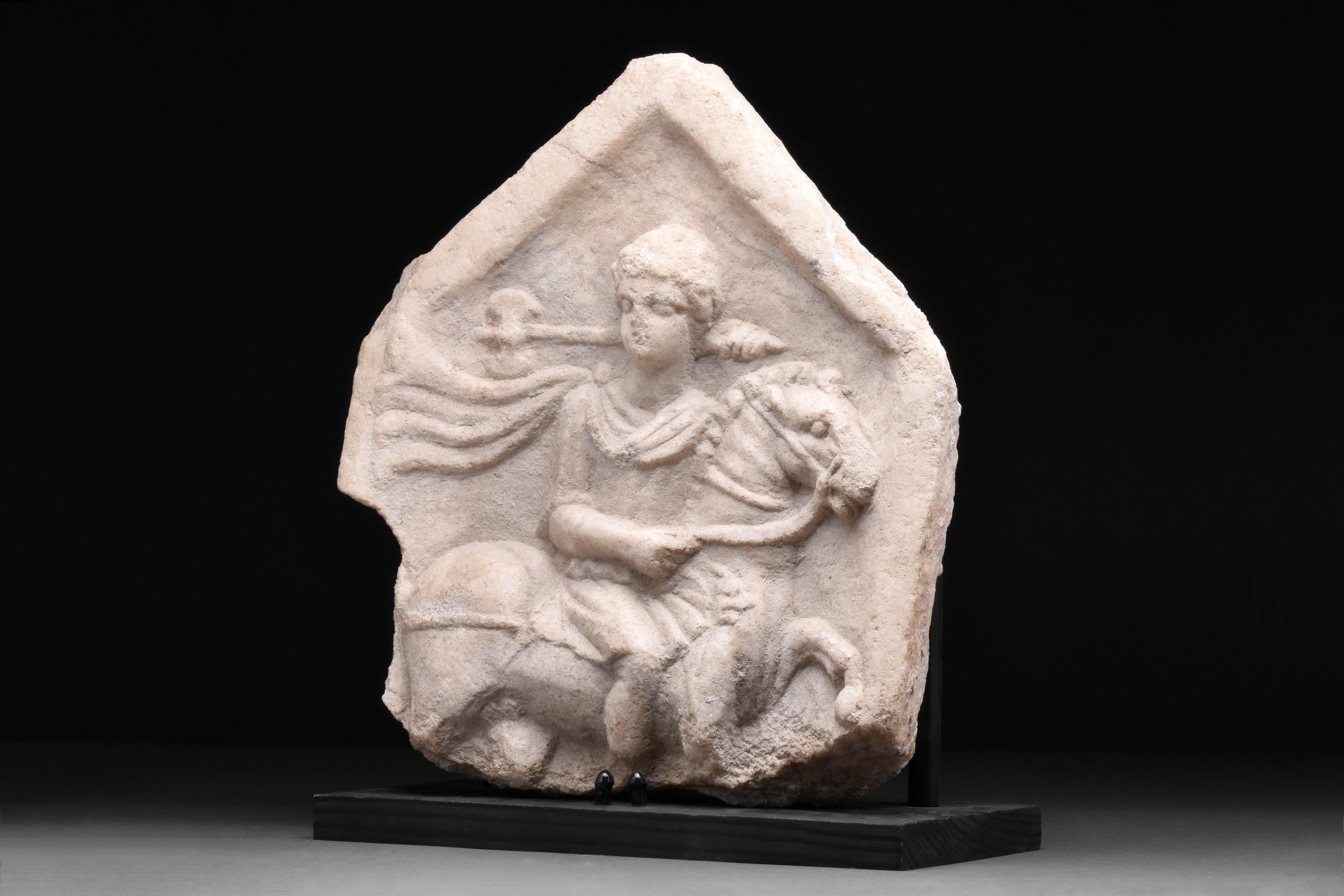 Circa Early 1st Century BC 

A magnificent ancient Roman marble relief stele of pentagon shape, finely carved with the relief of a young Apollo on horseback, holding doubled bitted axe called a Labrys. Apollo is depicting with parted lips, the