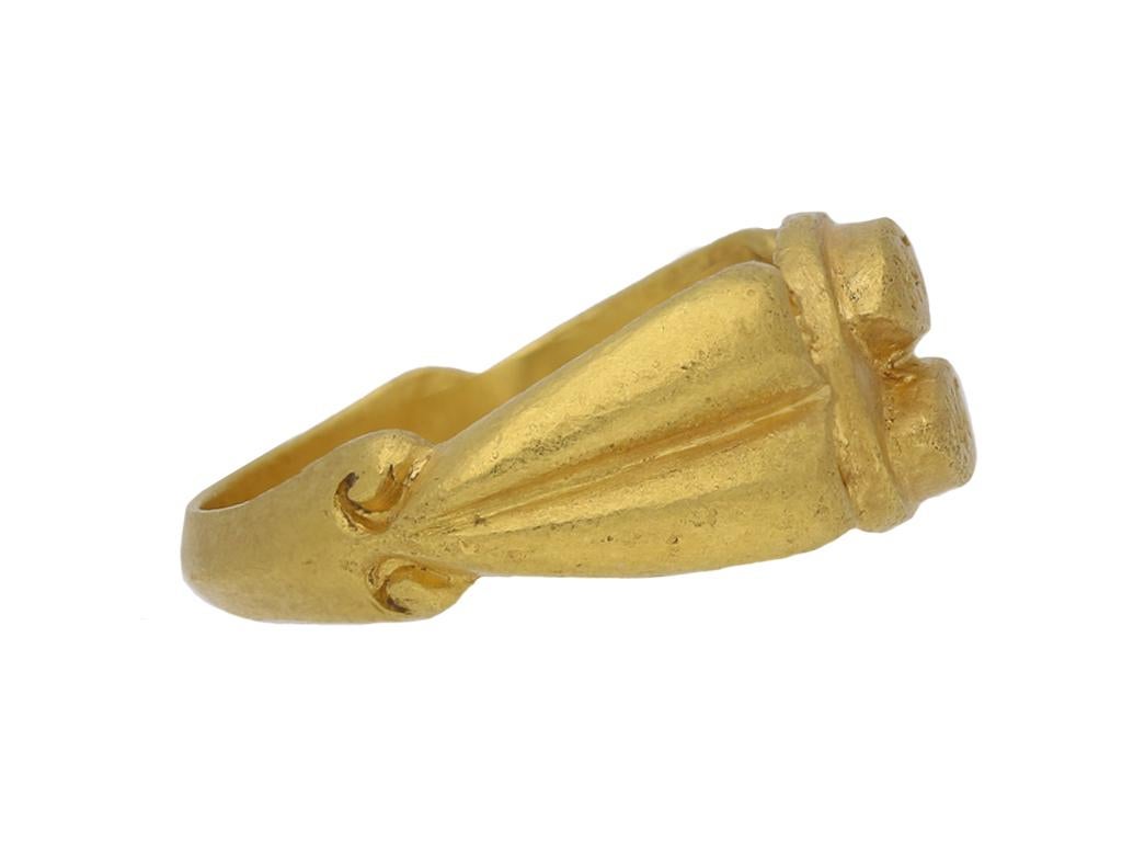 Ancient Roman 'Patri Matri' gold ring. The central elliptical plaque features two raised panels inscribed 'PATRI' and 'MATRI', translated from Latin as 'for father, for mother', flanked by broad ridged shoulders with curling volutes and tapering