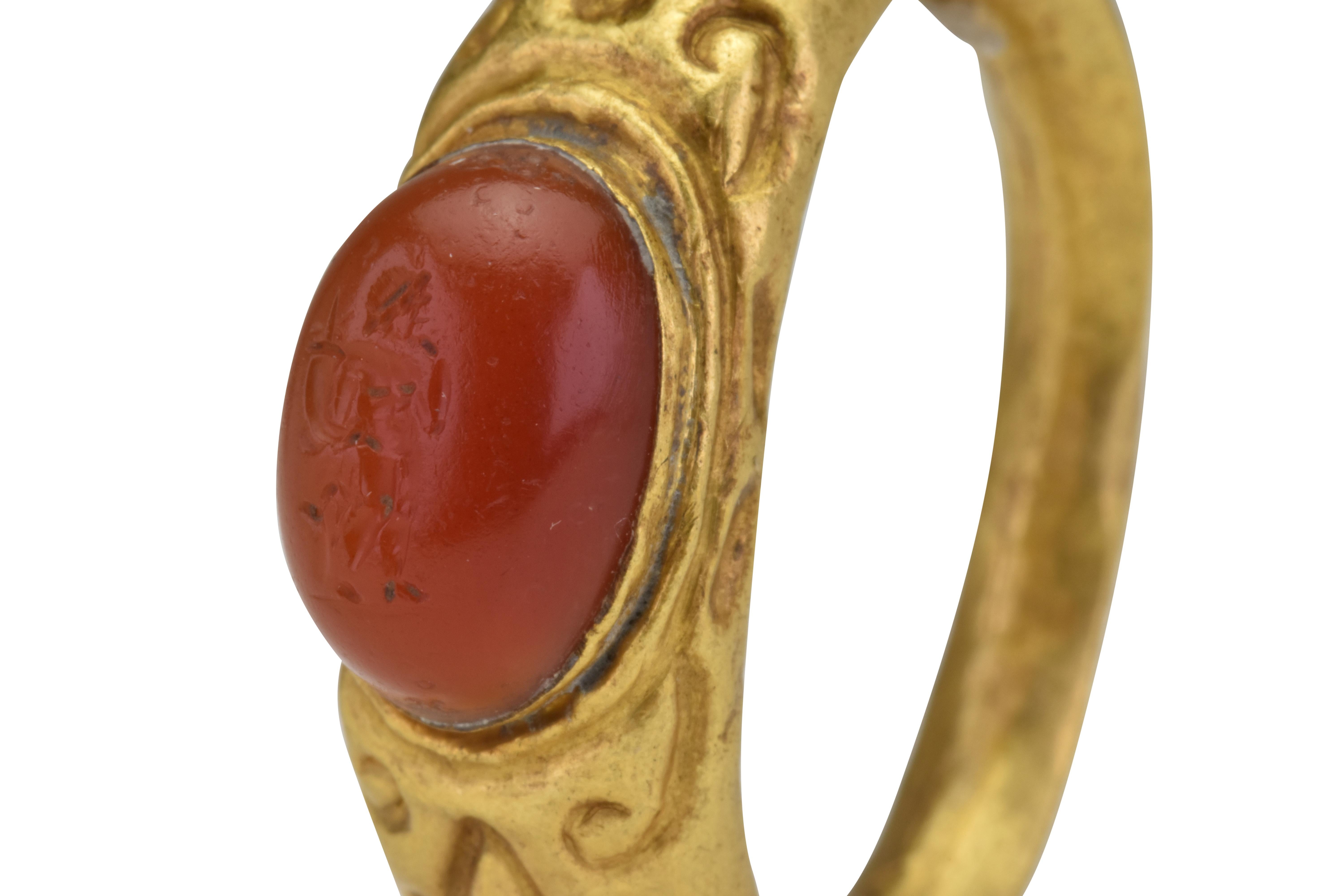 Ancient Roman Signet Gold Ring with Carnelian Intaglio
Ca. 100 - 300 AD
Gold Ring depicts a bearded god holding a cornucopia and an eagle in the background. 

Size: D: 8 5/8mm / US: 18.61 / UK: R; 6.28g

Provenance:  Private London collection;
