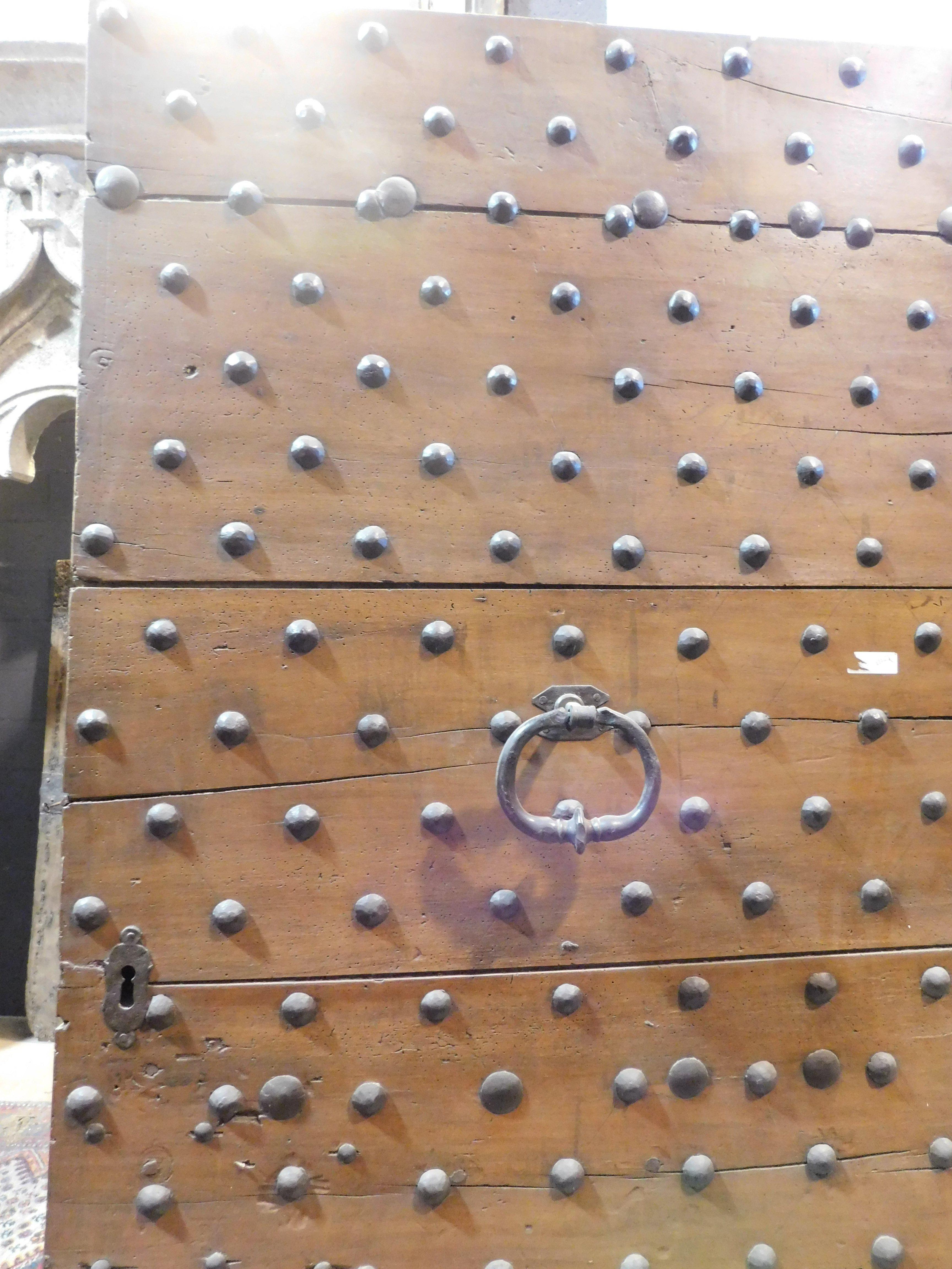Hand-Carved Old Rustic entrance door in walnut with nails, from northern Italy For Sale