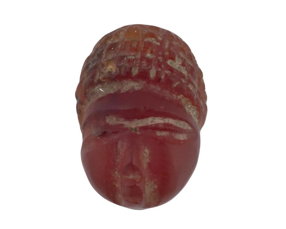 Une ancienne perle en intaille en agate rouge sculptée à la main par les Sassanides. La perle représente une tête avec une coiffure haute. Bijoux et accessoires de l'Antiquité sassanide et objets de collection.

Dimensions : 1/2 x 3/8 in. Toutes les