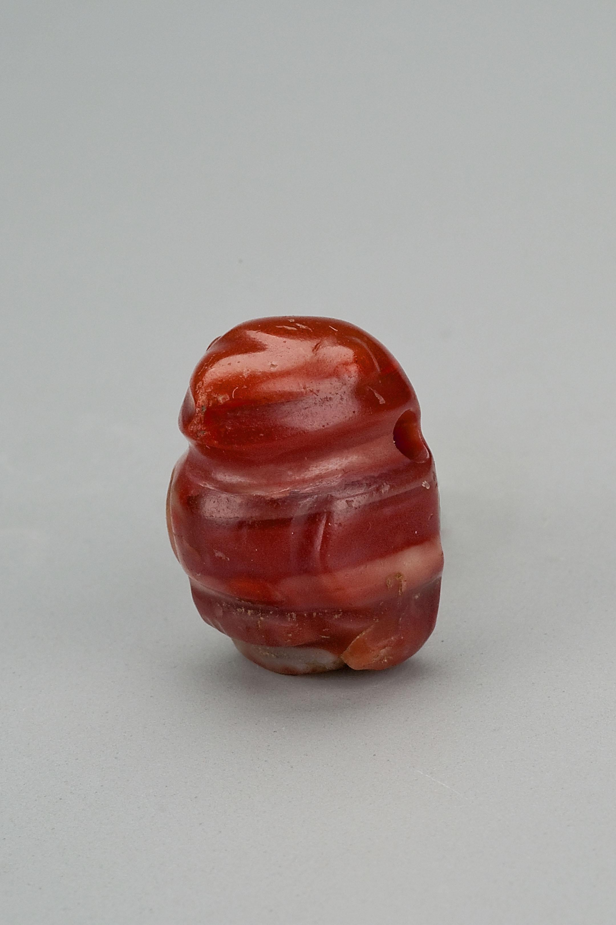 Twenty-four round gold beads with twenty-four round carnelian beads and a pair of cylindrical carnelian tubes. There are three bird pendants, two of red jasper and one of orange carnelian. The stone pieces are said to be from the Tairona people of