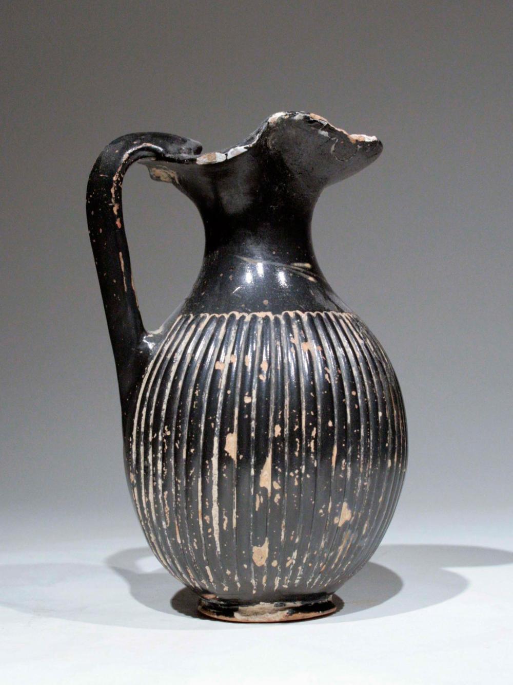 Oinochoe Greek, circa 350 BC., terracotta. H 13.2 cm.

Certified

Greece, Magna Graecia, Southern Italy, Apulia, circa 340-325 BCE. An oinochoe created in a pottery workshop in the Apulia region of southern Italy where potters were known for