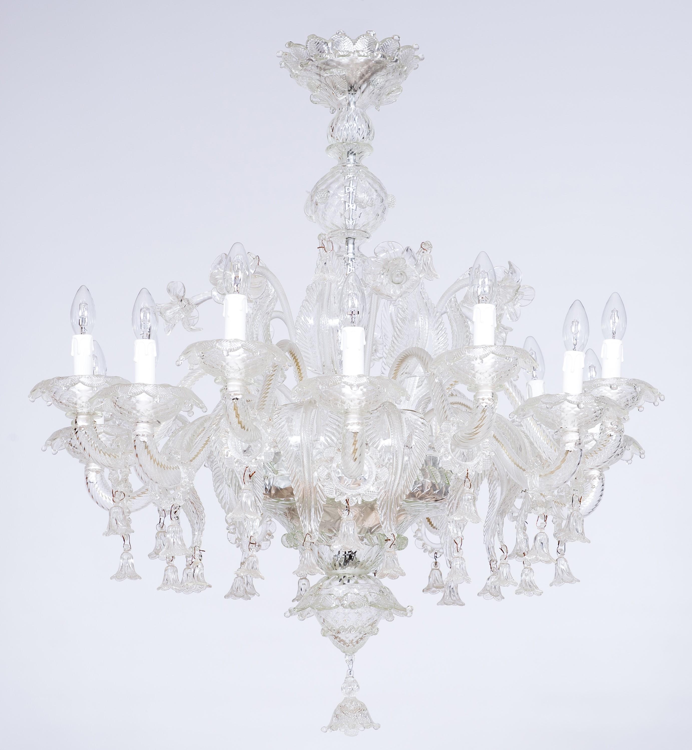 Venetian Chandelier in Transparent Murano Glass, Italy 1950s.
This beautiful chandelier was entirely hand-crafted in the island of Murano (Italy) during 1950s. This ancient artwork is characterized by an exquisitely decorated framework and 14 curved