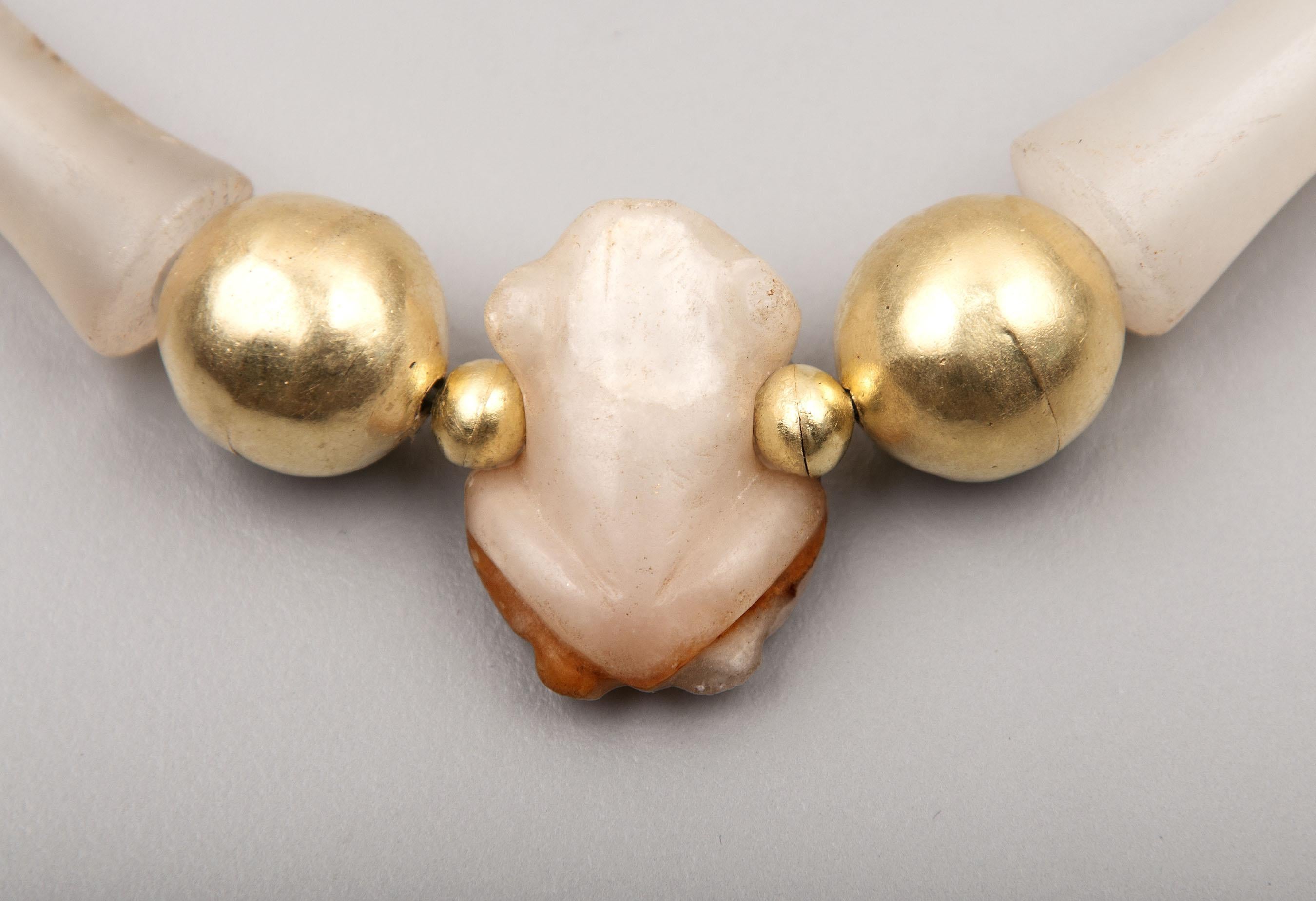Eight flared chalcedony beads of uncommon size said to be from the Tairona people of Colombia, South America. In the center is a bead in the form of a frog, also made from white chalcedony. The center bead is 2.45 cm in height, 1.8 cm in width at
