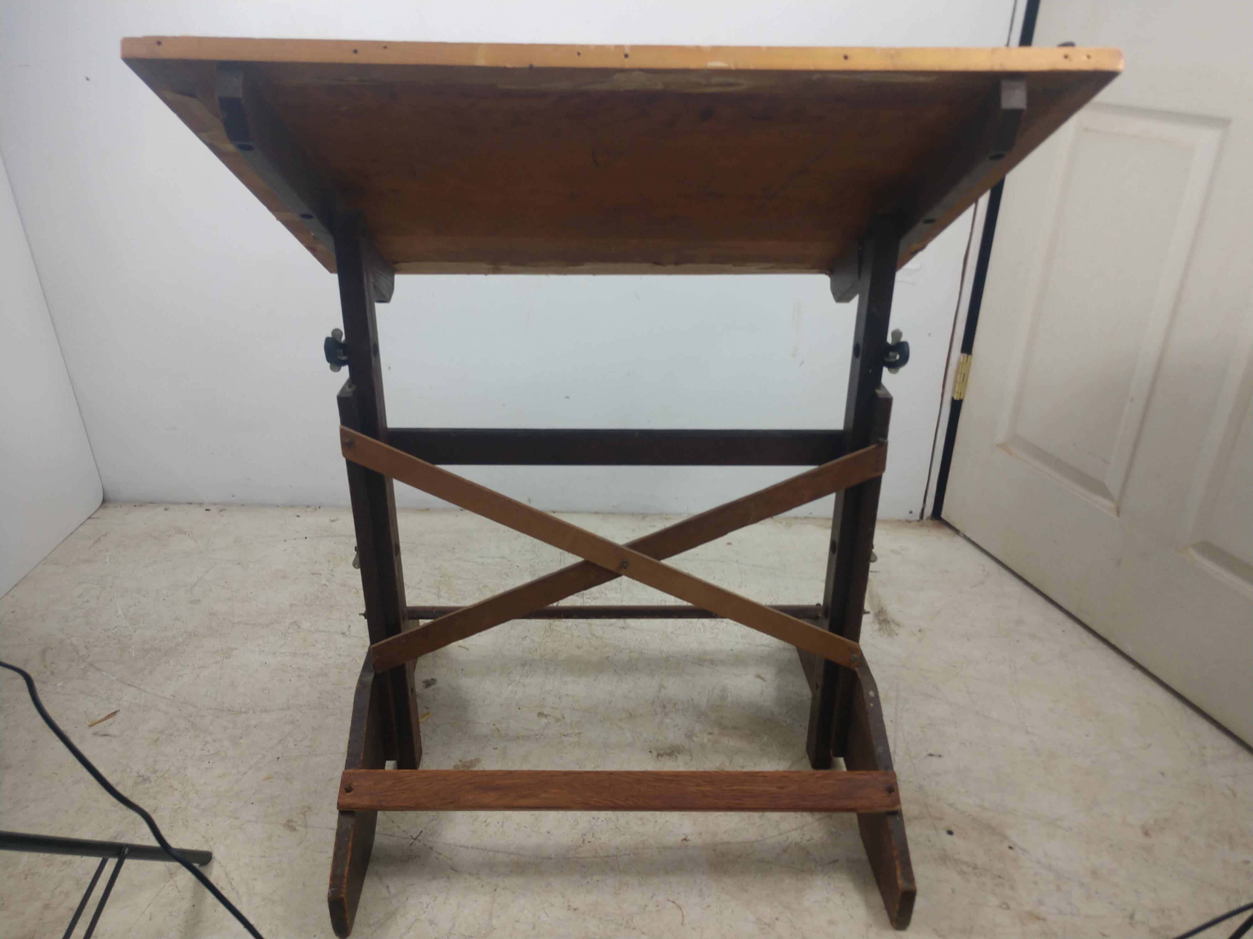 Diminutive pine top drafting table by Ancobilt. A 19th century company that is the premier and lasting builder of drafting tables. Sturdy and small, top is 31 x 23. Reaches a height of 42.5 and lowers to 31.5 iron brackets for adjusting to the angle