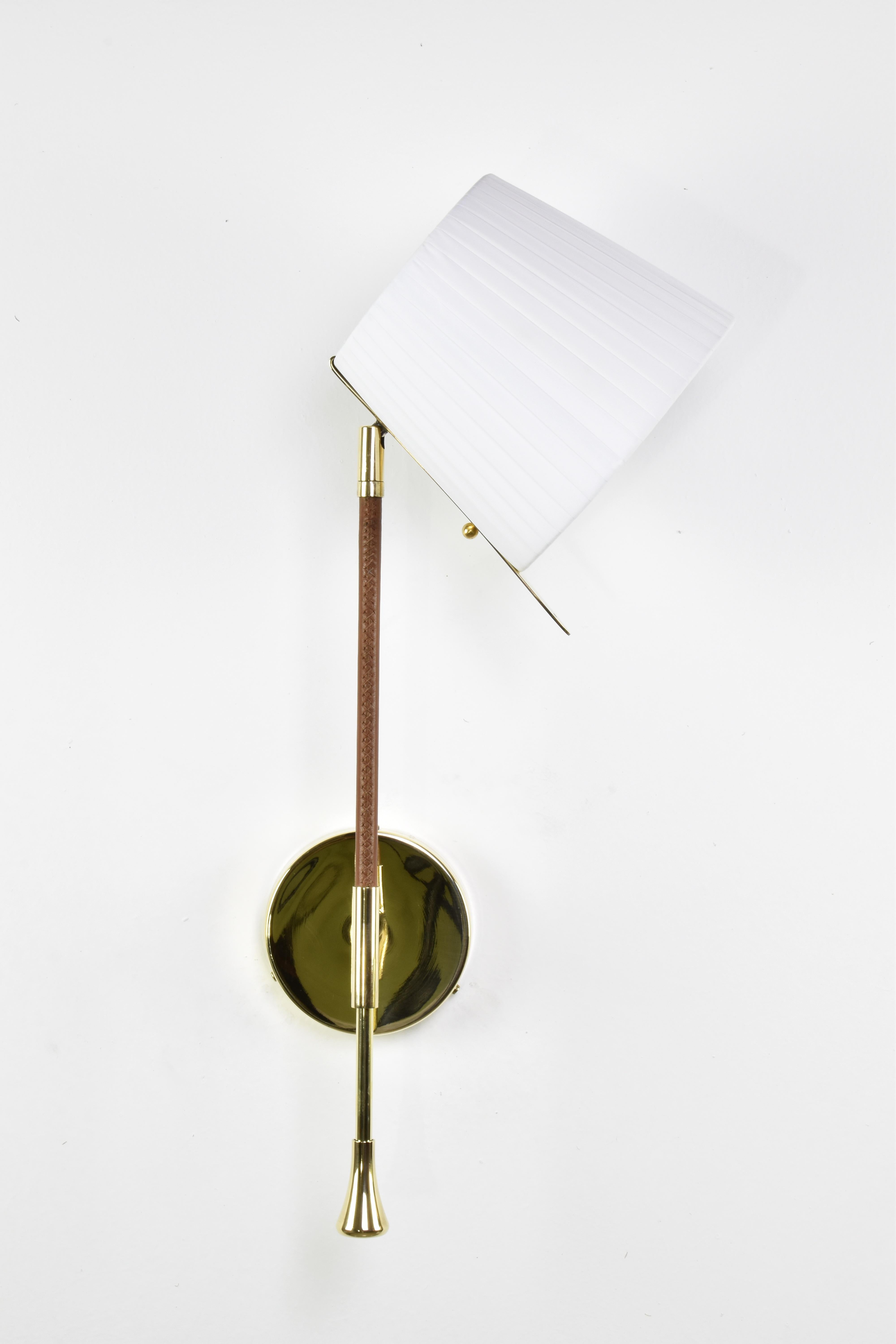 Aplique o candelabro de pared artesanal contemporáneo del siglo XXI, fabricado con una estructura de latón pulido dorado adornada con un detalle de cuero enfundado marrón cosido a mano por artesanos marcadores de silla de montar, una pantalla
