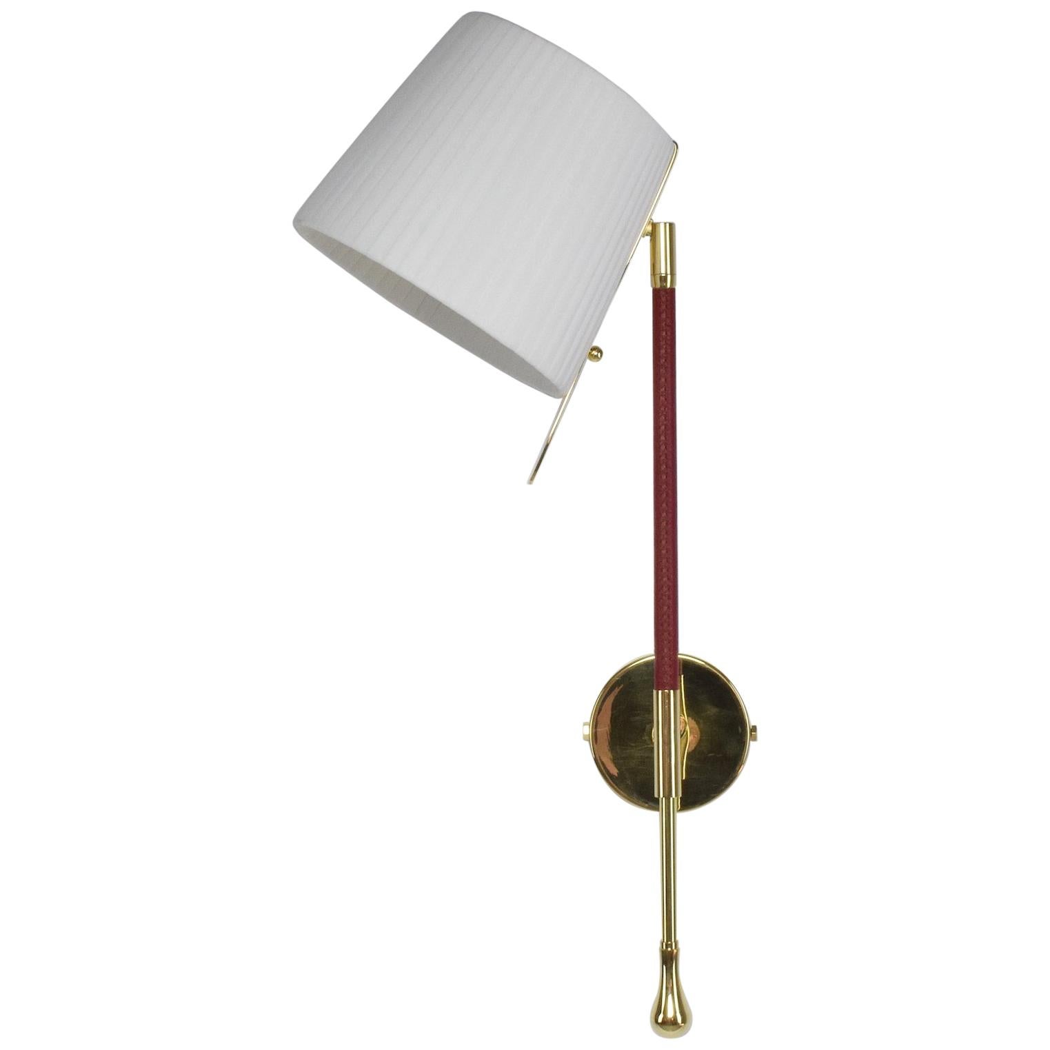 21st century contemporary handcrafted wall lamp fixture or sconce, made of a gold polished brass structure adorned with a brown sheathed leather detail hand sewn by artisan saddle markers, a white soft fabric pleated shade with 90° rotation which is
