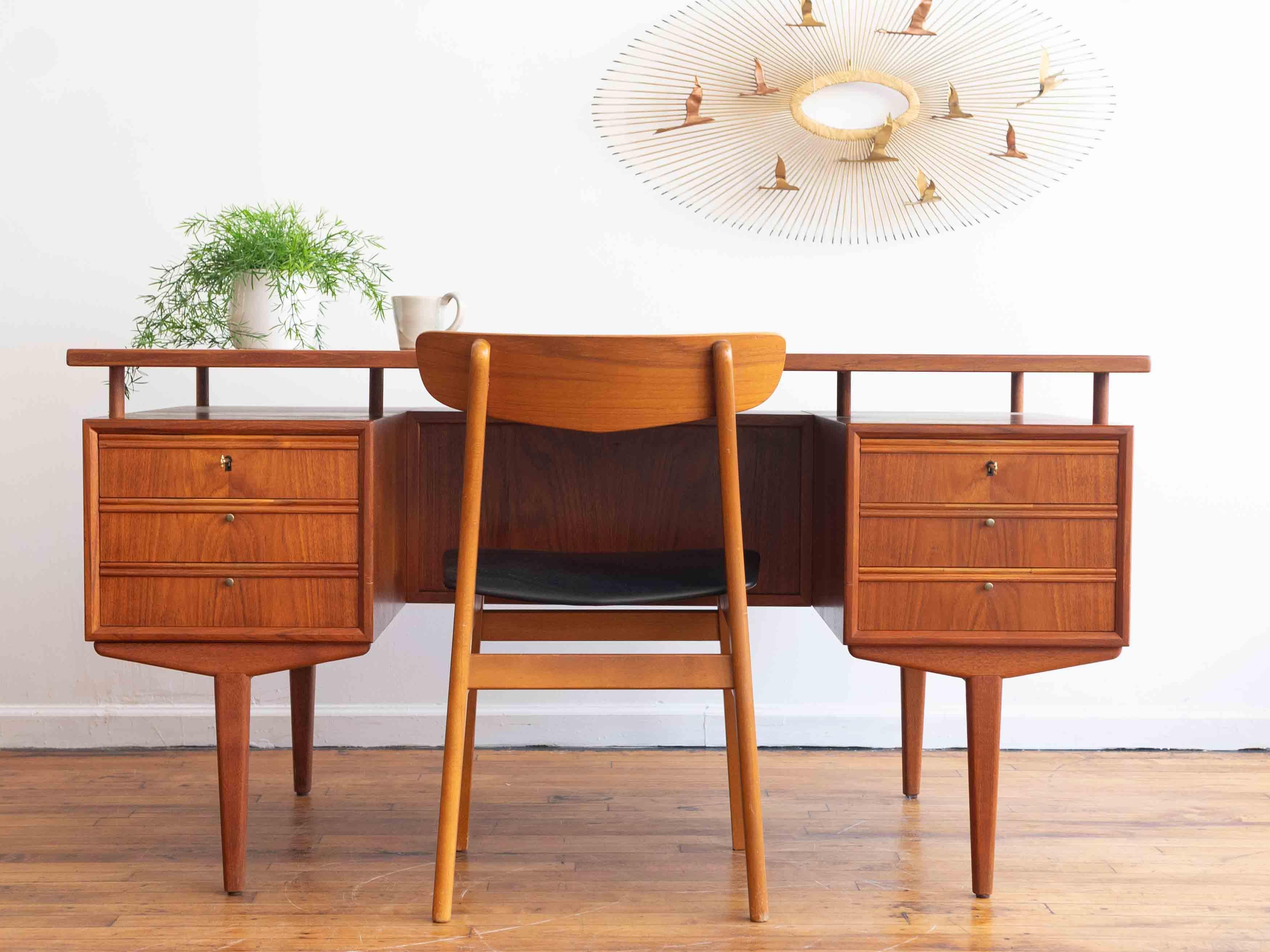 57” x 29.5” x 29.5”H; knee hole 28.5” x 25”H

Striking Danish teak desk with a floating top.

•extra large work surface
•six drawers, two of which lock
•long tapered legs
•finished back
•bookshelf storage integrated into the back of the drawer