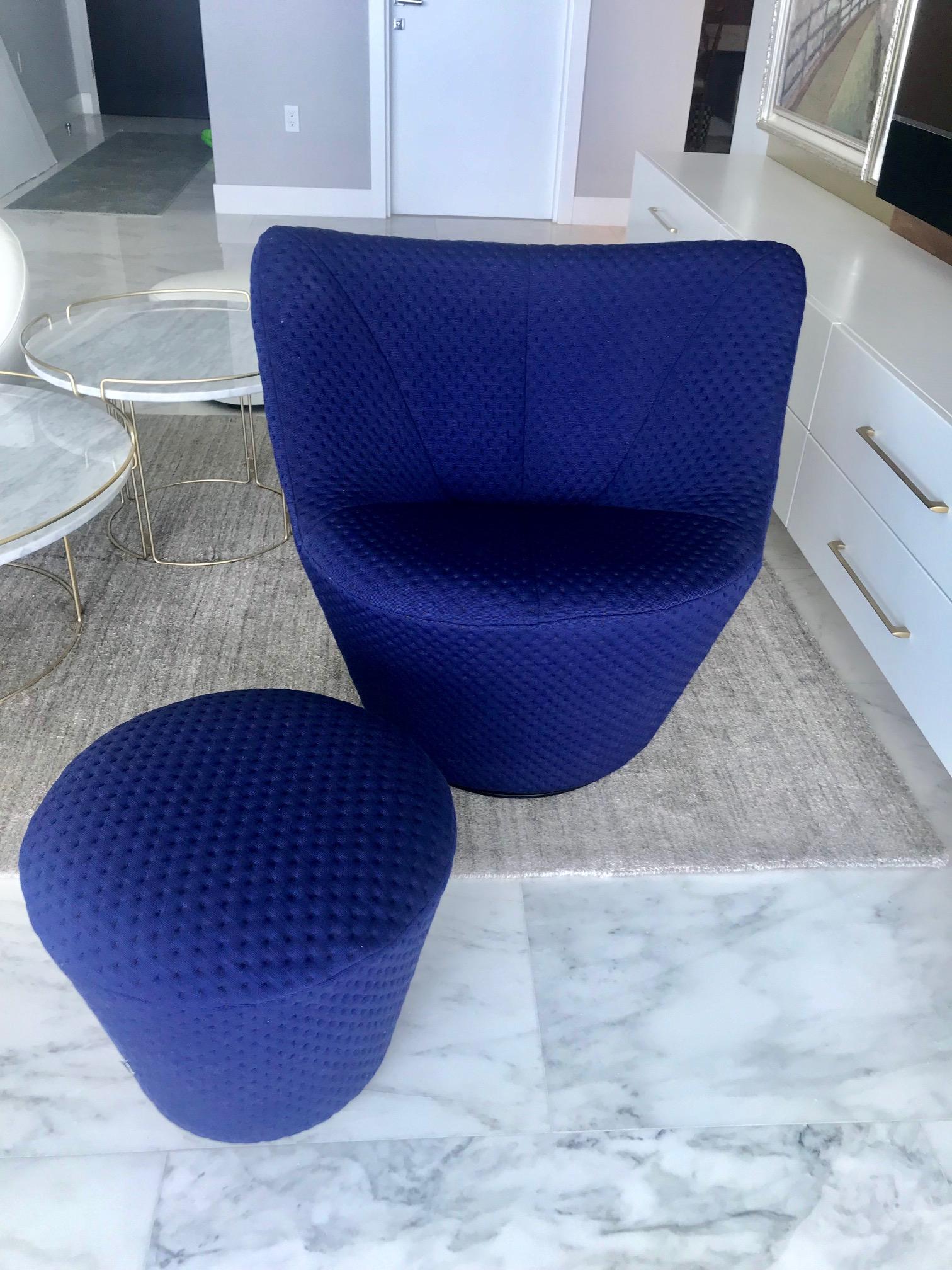 Outstanding swivel lounge chair and matching ottoman designed by Pierre Paulin. Modernist design with elegant curves throughout. Offers exceptional comfort with low back design and swivel base feature. Custom woven upholstery in vibrant mood indigo