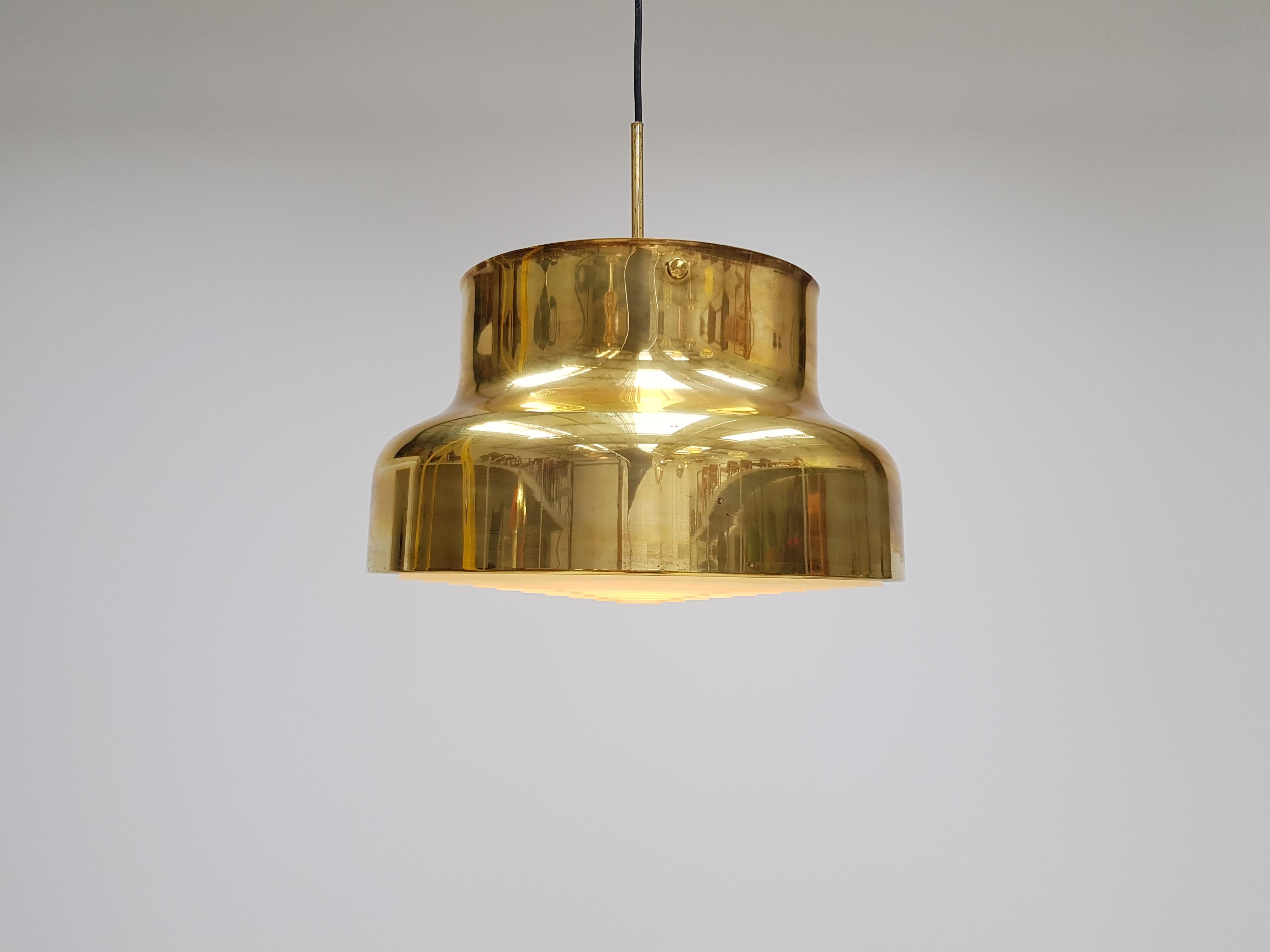 Brass ceiling pendant Bumling by Anders Pehrson for Atelije Lyktan, Sweden, 1970s. 

Anders Pehrson took over the company in 1964. He would come to put his personal stamp on development in the company until the end of the 1970s. He was a