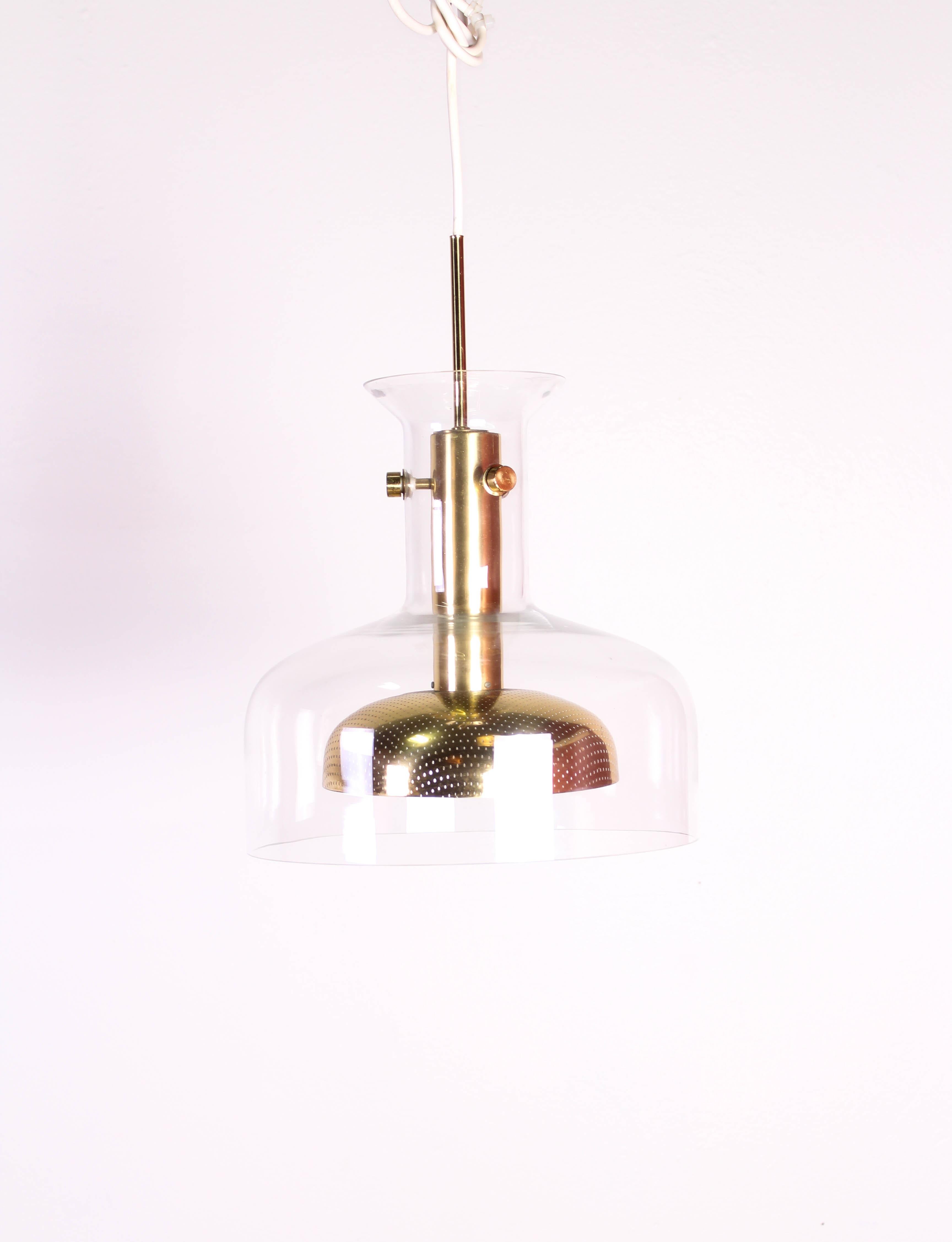 Midcentury ceiling lamp designed by Anders Pehrson for Ateljé Lyktan, Sweden. The lamp is made out of brass and glass with working wiring. The brass has some patina on it, see pictures but the overall condition of this rare lamp is very good.