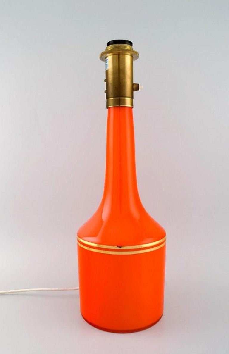 Anders Pehrson für Ateljé Lyktan. 
Zwei große Tischlampen aus orangefarbenem mundgeblasenem Kunstglas mit Golddekor. 
1960s.
Maße: 50 x 16 cm.
In ausgezeichnetem Zustand.
Etikett.
