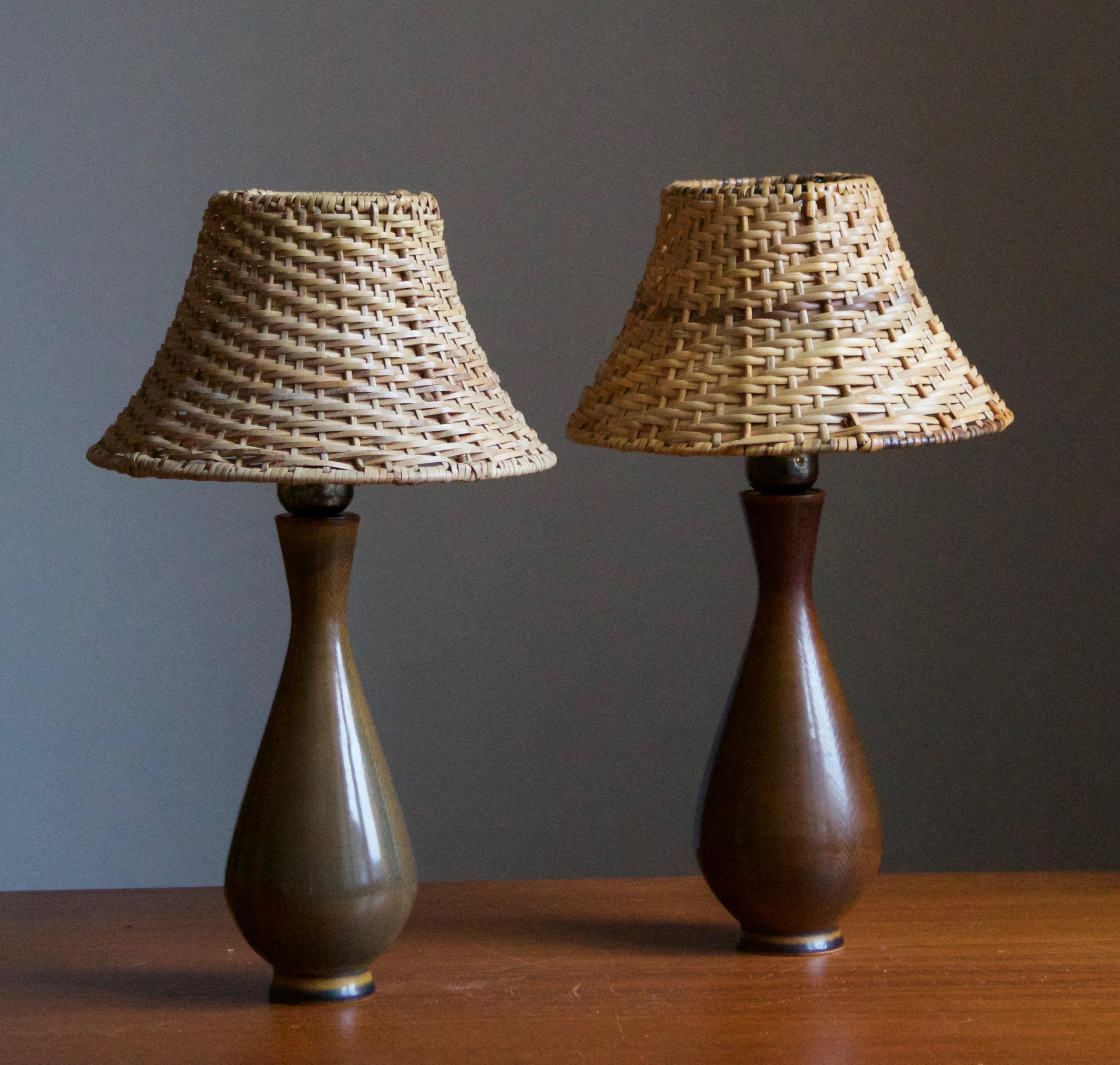 A pair of table lamps, produced by Andersson Johansson, Höganäs, Sweden, c. 1940s.

Features simple hand-painted decor.

Stated dimensions exclude lampshade. Height includes socket. Upon request illustrated model vintage rattan lampshades can be