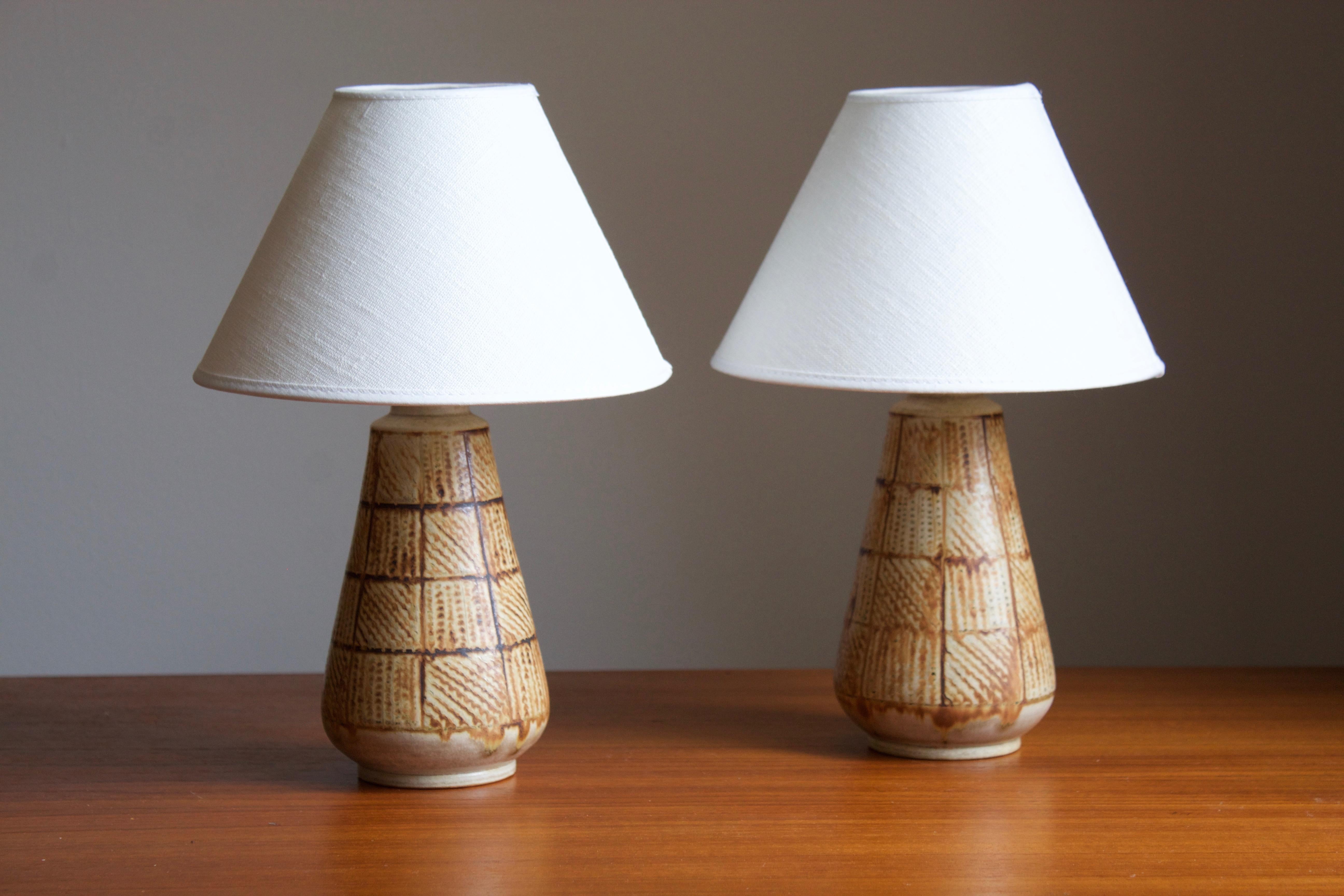 A pair of table lamps, produced by Andersson Johansson, Höganäs, Sweden, 1930s. Features simple incised and hand-painted decor. In stone or earthenware.

Sold without lampshades. Stated dimensions exclude lampshades. 

Glaze features brown-beige