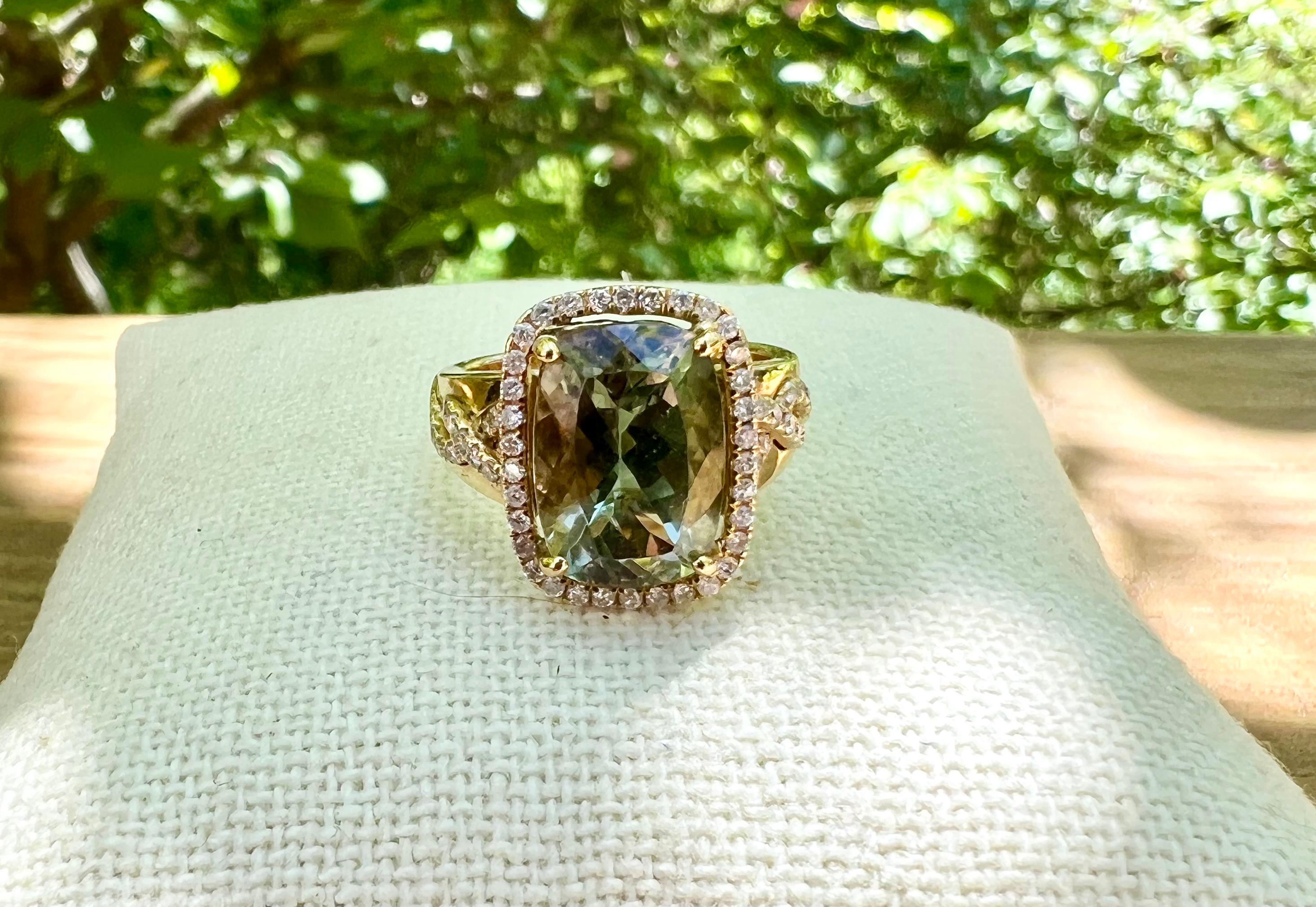 One 14 karat yellow gold ring set with one 13 x 9.25mm cushion cut green andesine surrounded by a halo of 0.62 carat total weight of brilliant-cut diamonds, with matching SI2-I1 clarity.  The ring is a finger size 7 and can be resized. Weighs 8.2