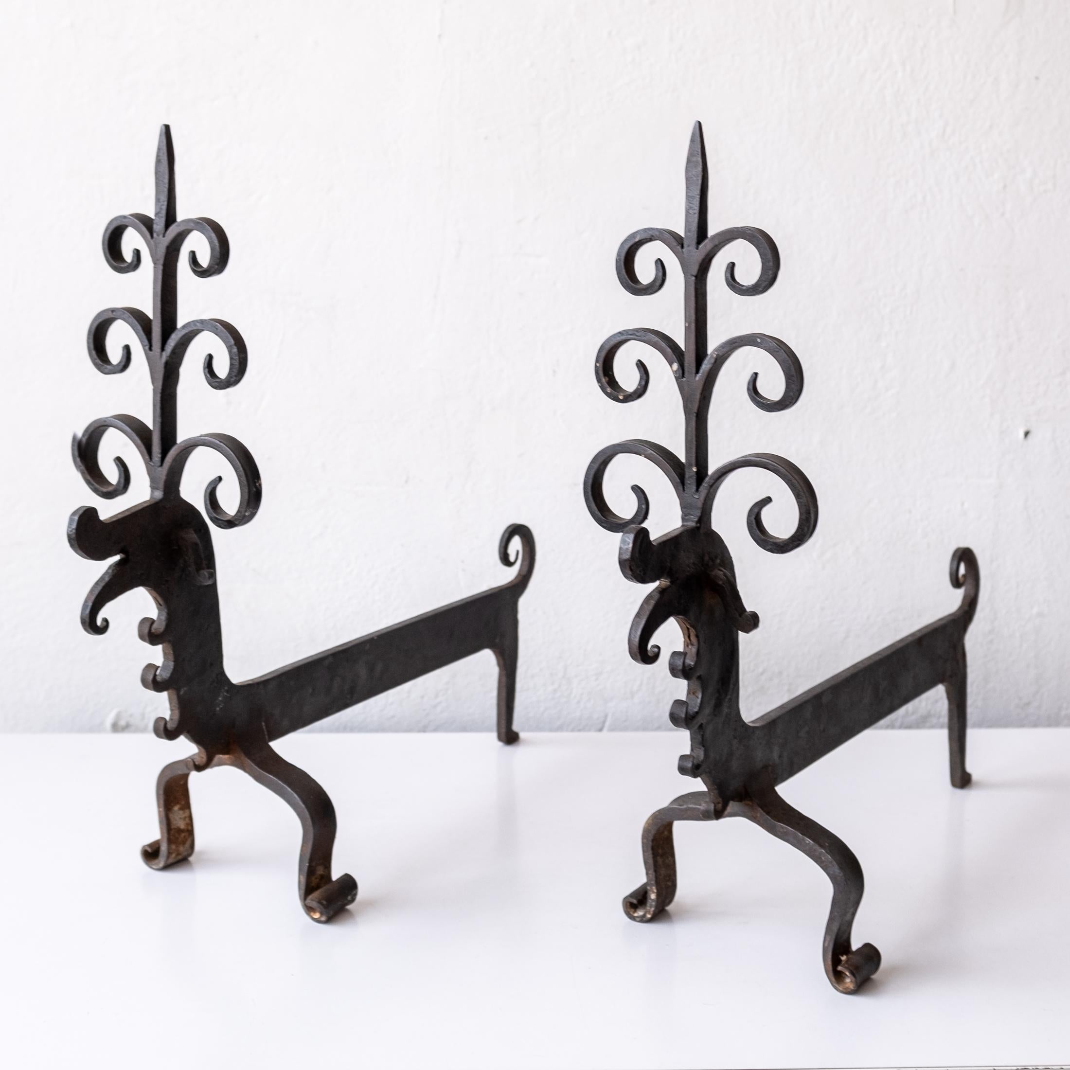 Arts & Craft andirons in the manner of Samuel Yellin. Great small scale with large and wonderful character. Handwrought piece with scrolled front legs.