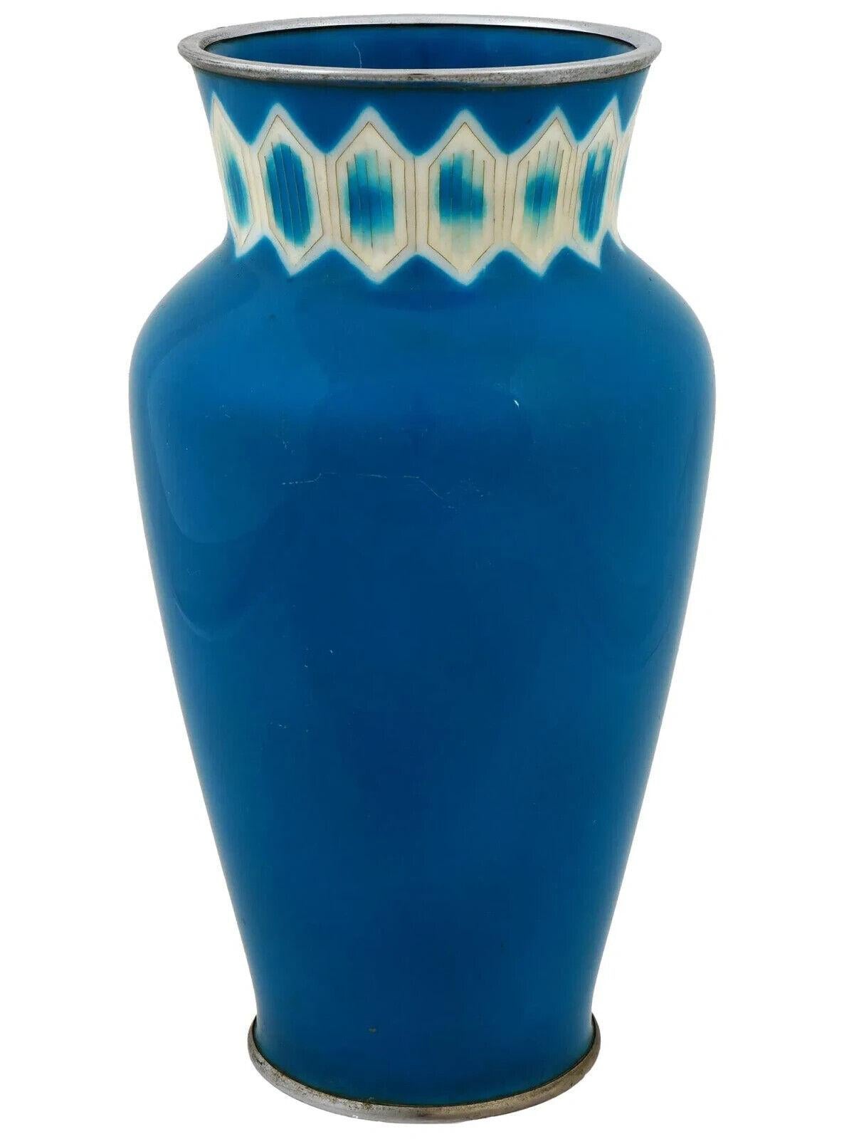An Ando Factory Japanese enamel vase. The vase has an urn shaped body and a wide neck with a fluted mouth. The vase is covered with enamel in a blue shade and decorated with a symmetrical diamond ornament on the neck made in the Cloisonne technique.