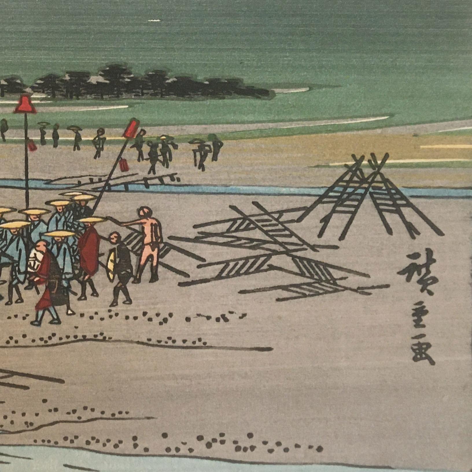 An ink on paper, Nishiki-e and Yoko-e woodblock landscape showing a group of figures unloading goods on the bank of the Oi River near Kanaya in Shizuoka Prefecture, Japan. Signed in Kanji lower right, 