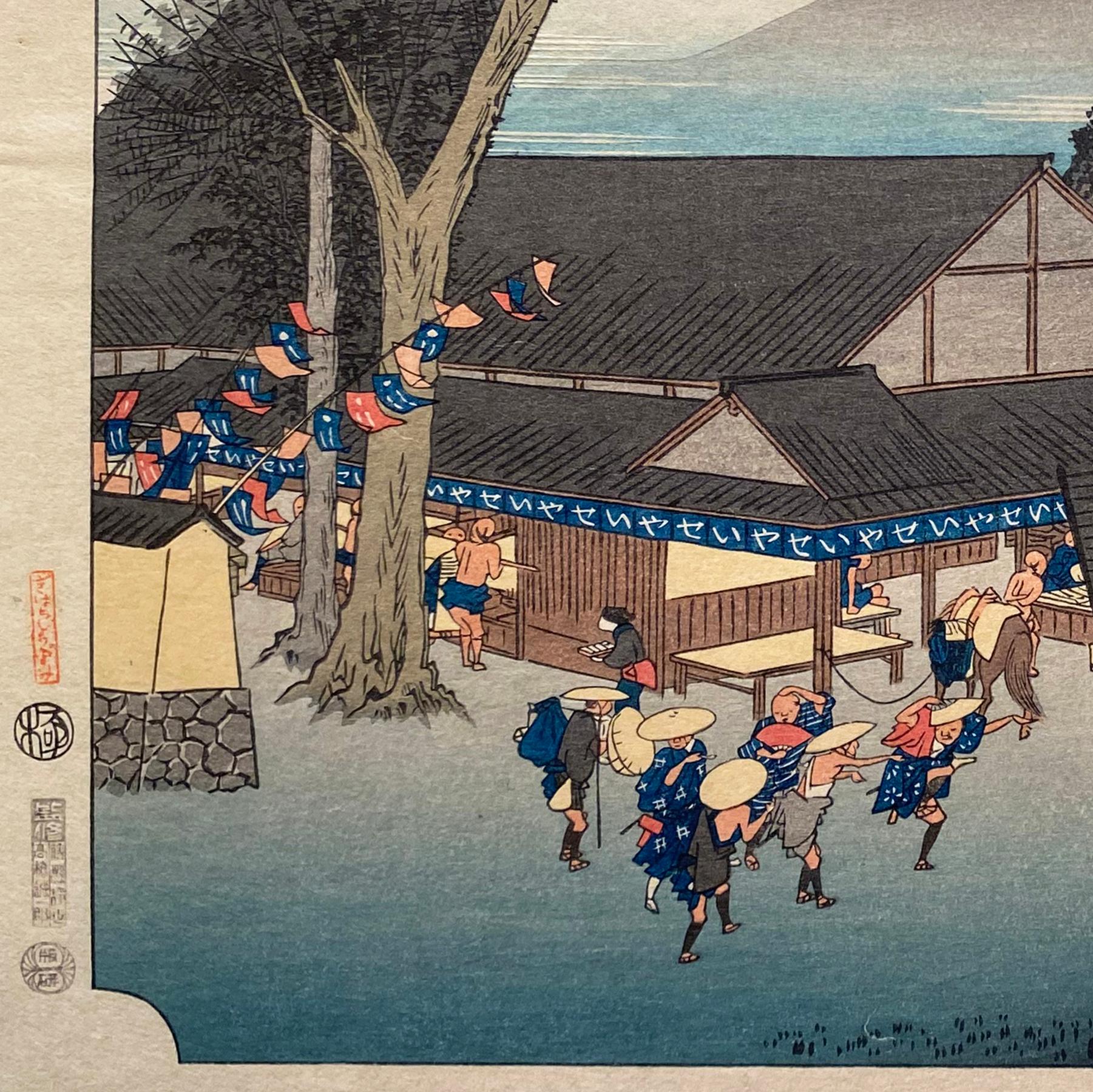 An ink on paper, Nishiki-e and Yoko-e woodblock landscape showing Megawa Village's station at Ishibe where travelers enjoy tea, food and entertainment beneath tall trees. Signed in Kanji upper right, 
