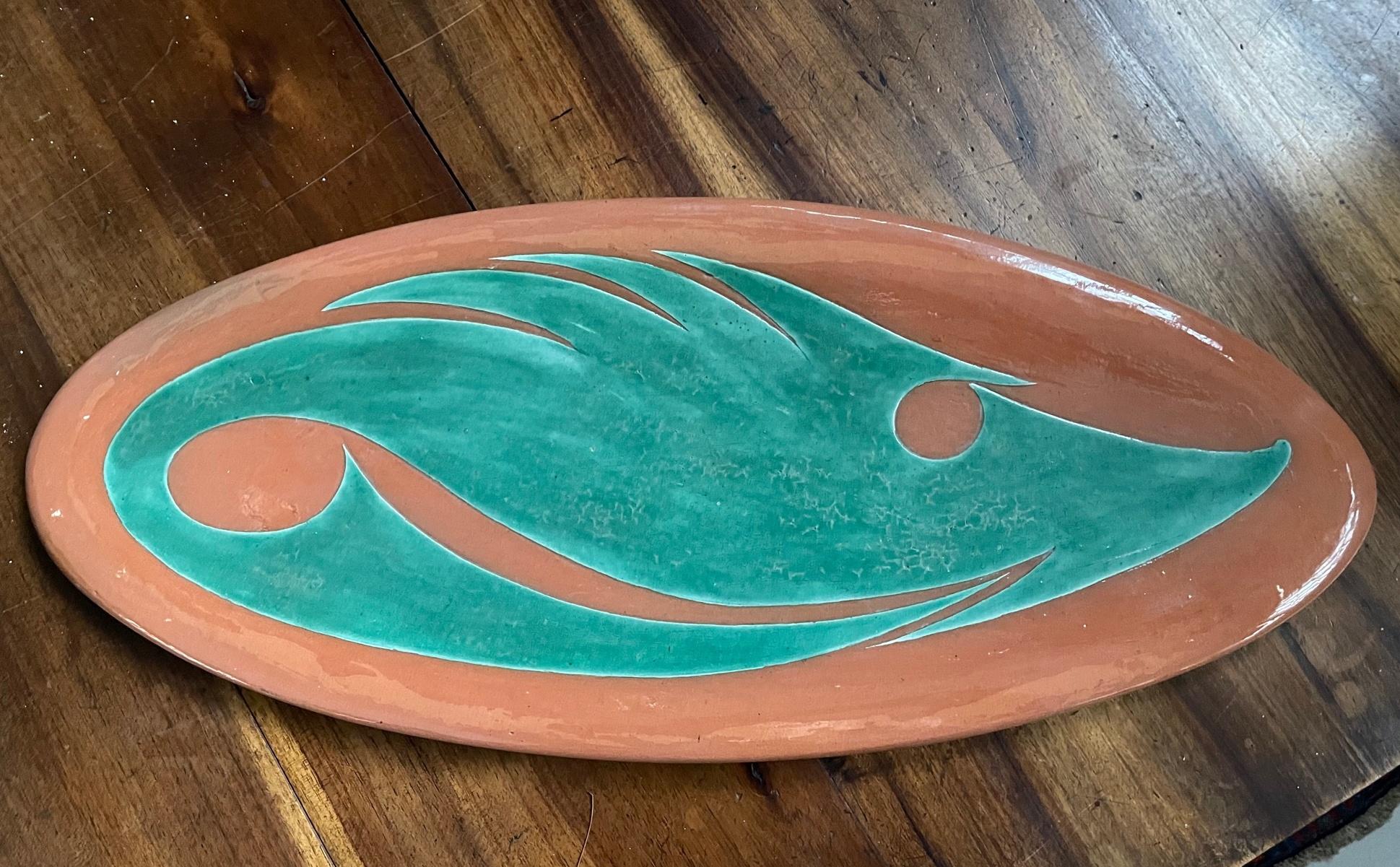 An early French, c.1950, polychrome ceramic platter by master ceramist André Aleth Masson, of oblong organic shape decorated with stylized fish in green, signed and dated 1951 and with triskel on the back.