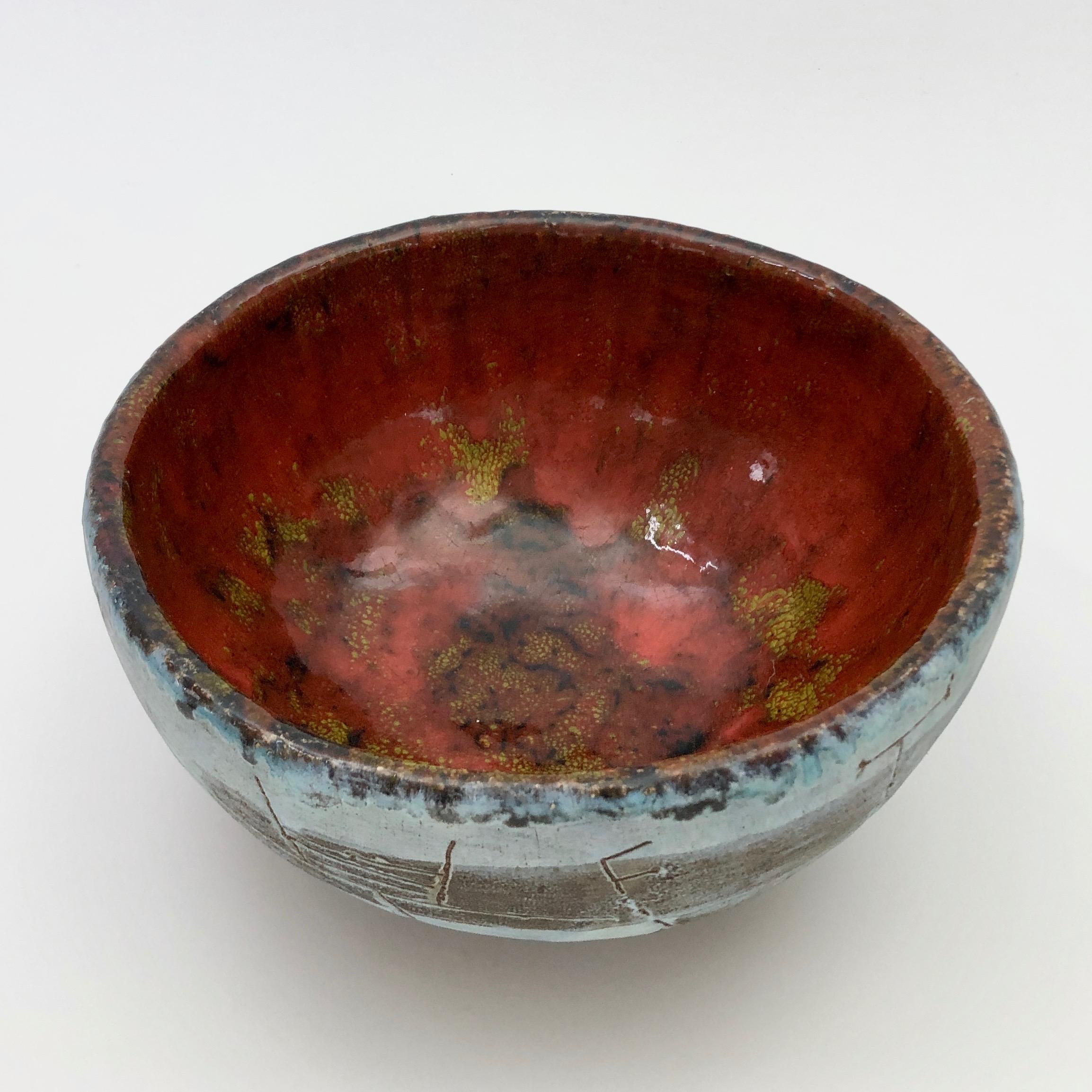 Rare ceramic bowl glazed in shades of matte blue, brown and glossy orange / red inside, decorated with abstract designs incised overall.
France, circa end of 1970s, 1980s.
Piece signed on the bottom A Masson, (St Malo ?).
 