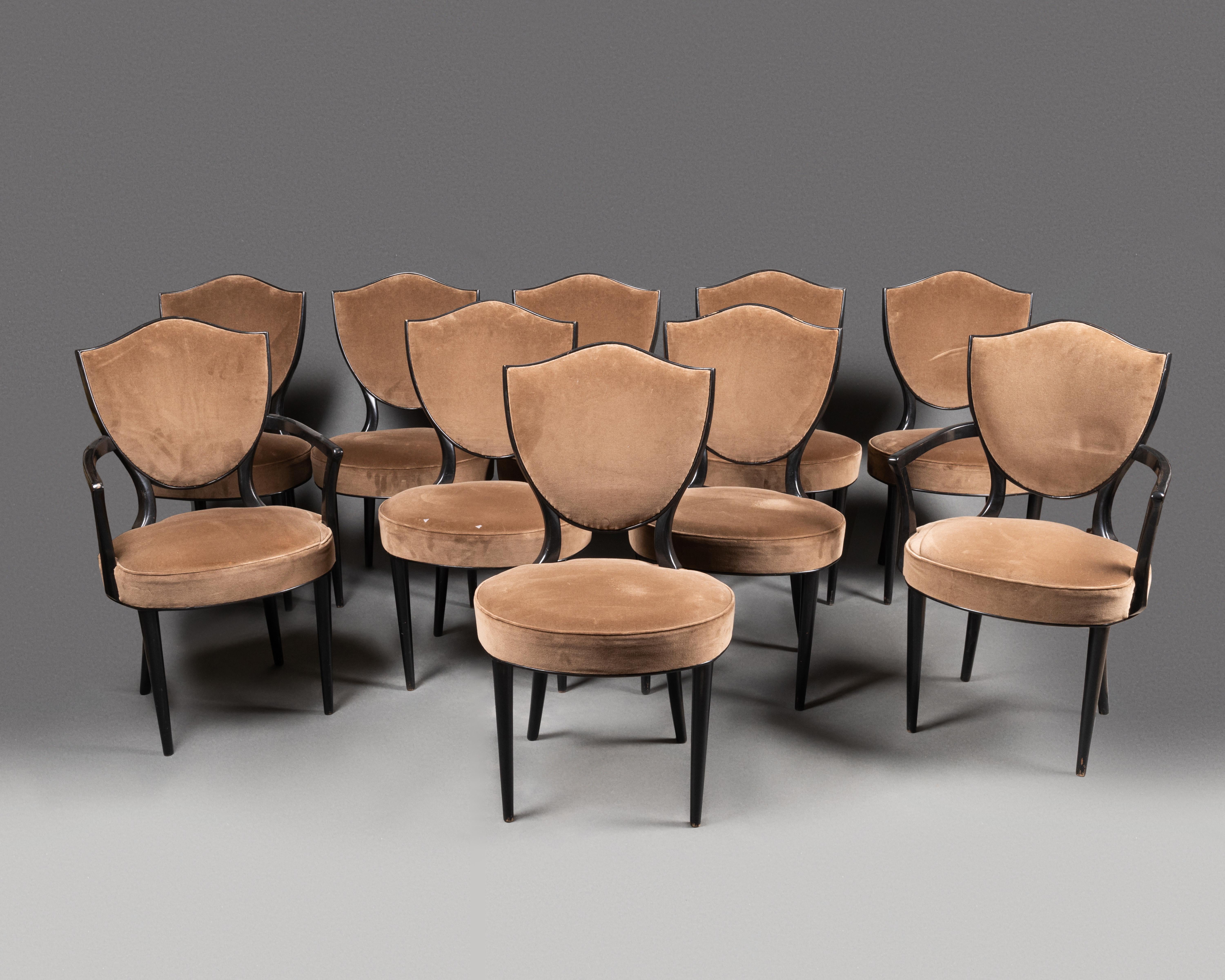 André Arbus dining room set. Oak table in ebonized pearwood. 8 chairs and 2 armchairs with medallion backrest, conical front and saber back legs. Covered in Havana velvet.

  Table 
H. 71cm (28”)
L. 230cm (91”)
D. 100cm (39”)

Chair
H. 82cm (32”)
L.