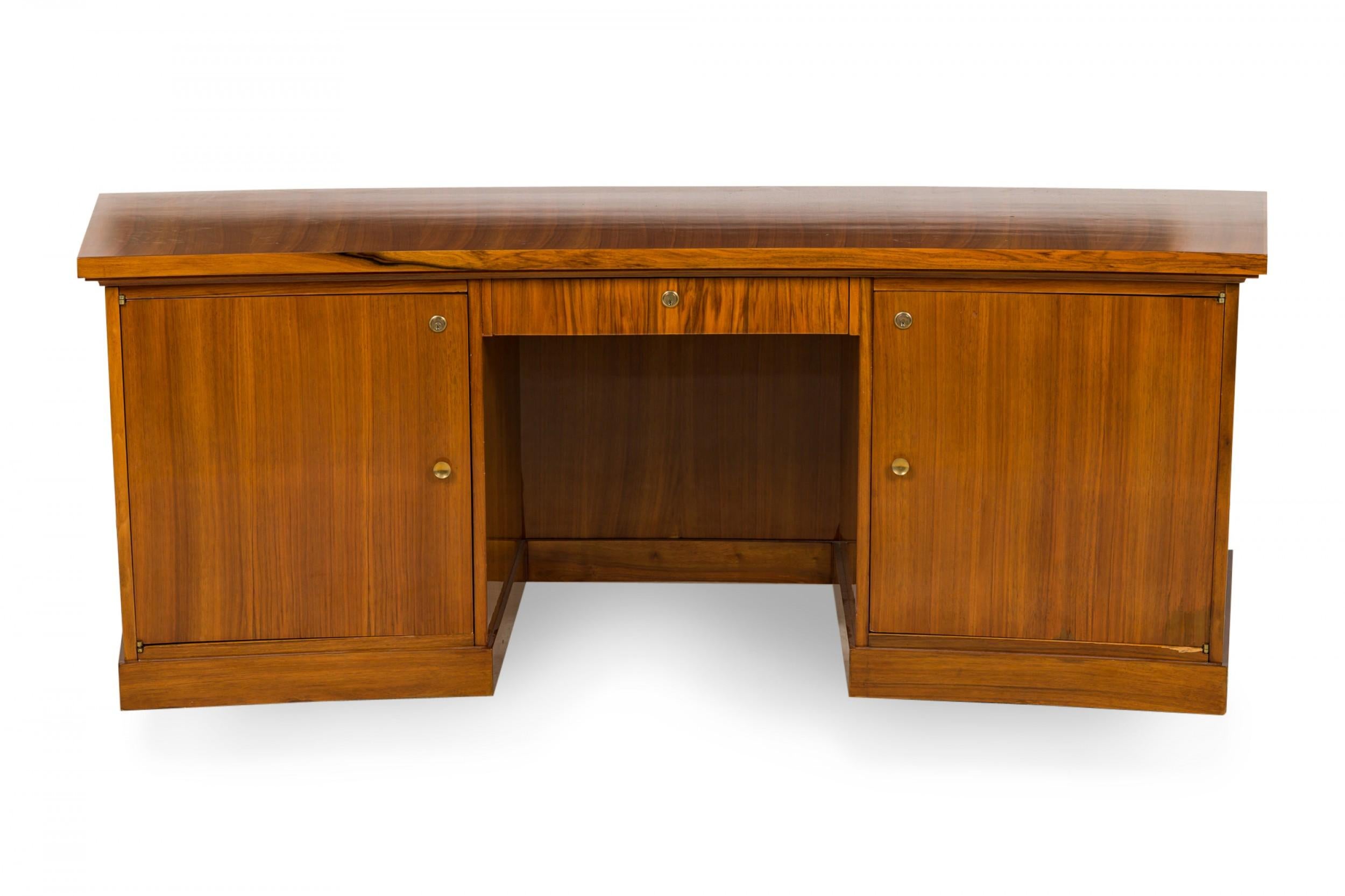 French Art Deco (circa 1945) executive desk with gently curved rectangular profile made of blond rosewood with bronze trim, containing two lockable cabinets, the left containing two shelves and the right concealing three interior drawers, and a