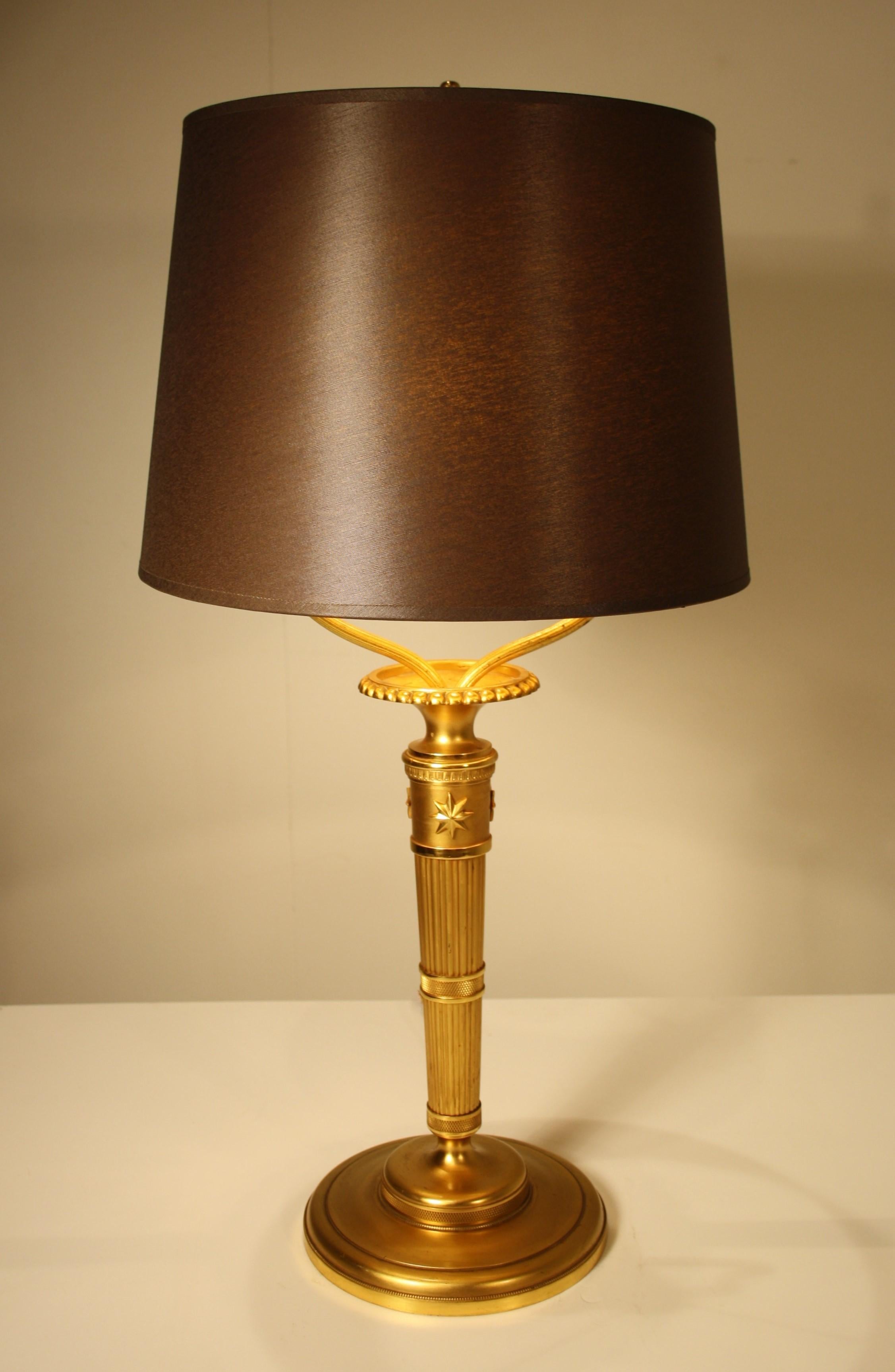 A finely chiselled gilded bronze table lamp by Andre Arbus, 1930s in neoclassical style.
The lampshade has been changed and is doubled inside with gold color.

 