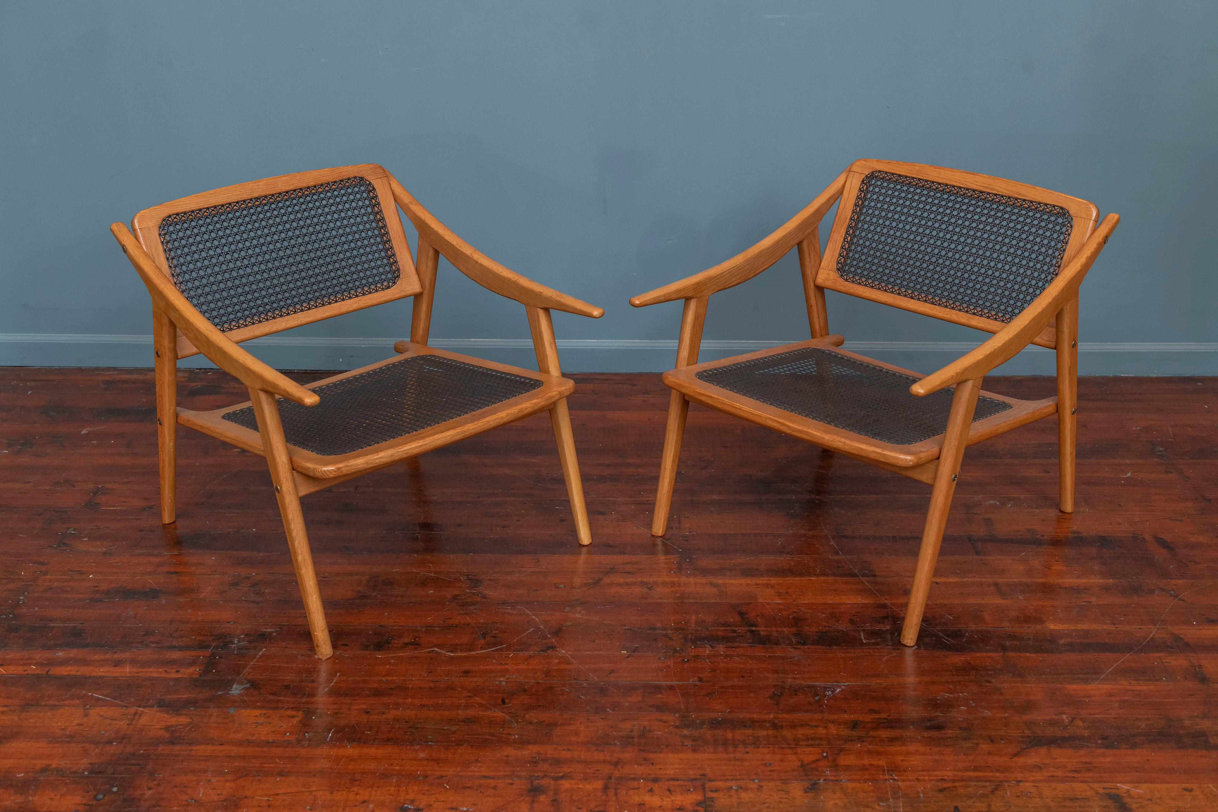 Exceptional pair of cane and oak lounge chairs by French architect and designer, Andre Baudoin. France, 1950. 
Provenance: Commissioned for a property in Le Havre, France decorated by Andre Baudoin in the 1950s.