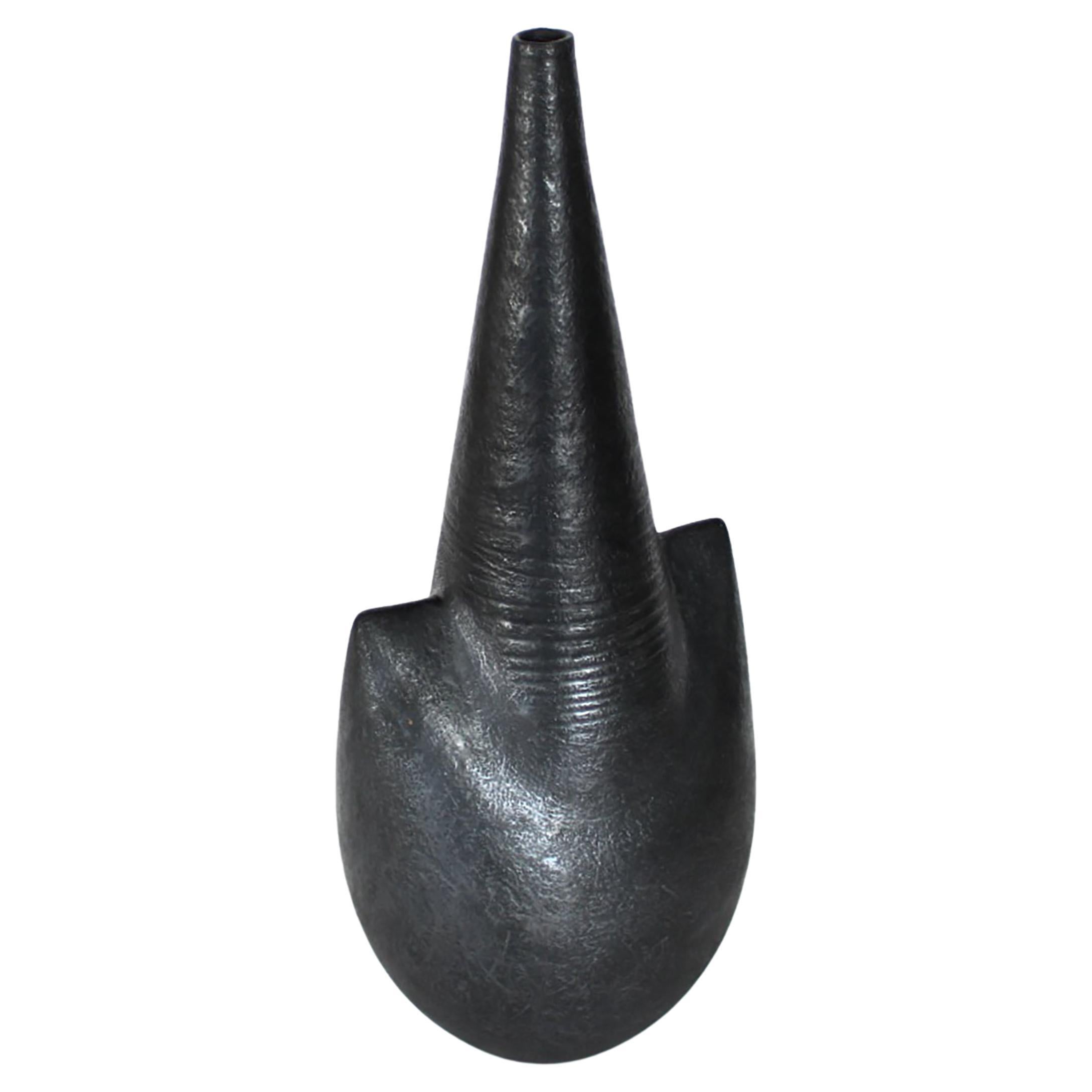 A tall ceramic vase by French artist Andre Bloch. Bloch uses a heavily grogged clay and deep black glaze to create his unique forms. Circa 2010

