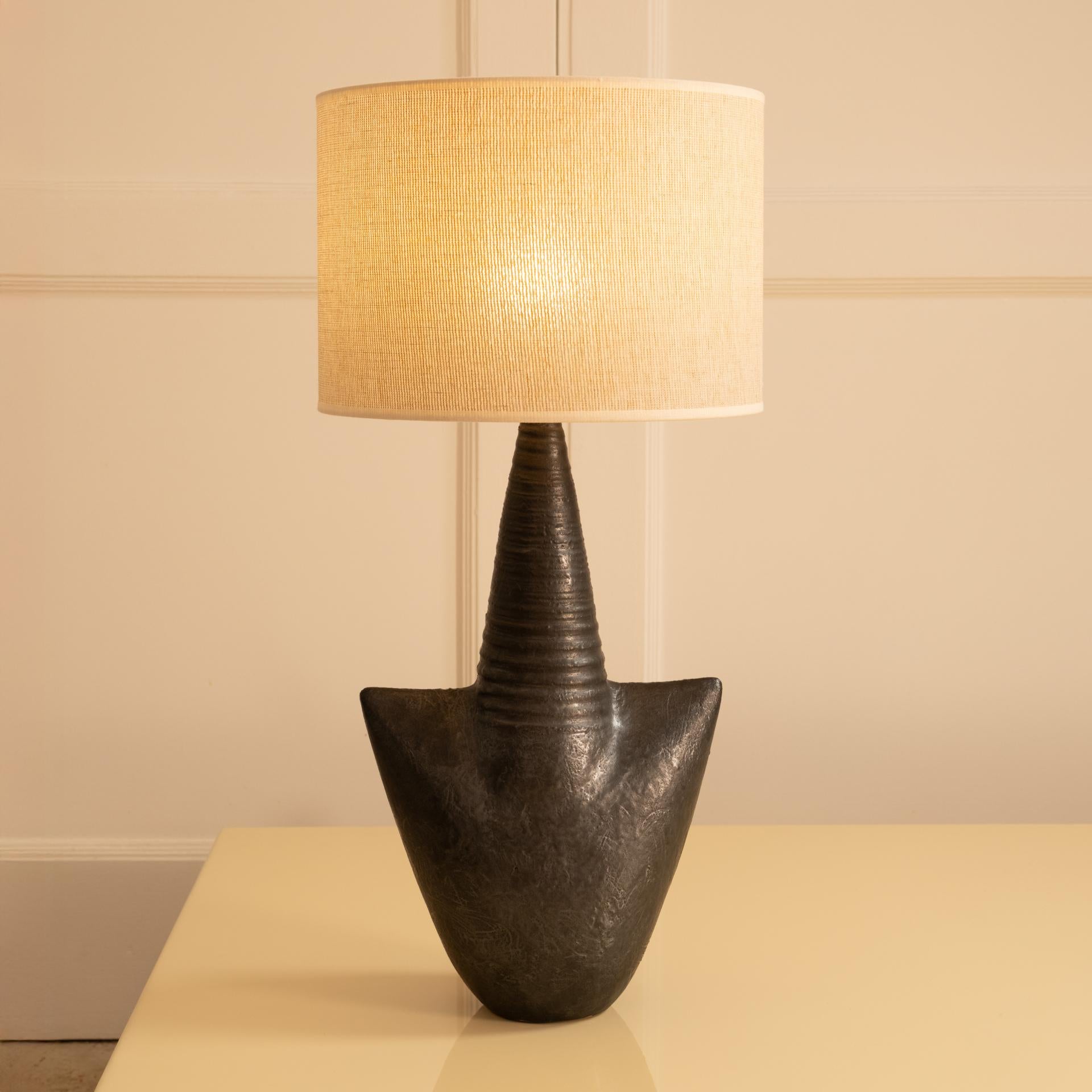 Contemporary sculptural lamp by Andre Bloch in single-fired stoneware.

Black base with gray highlights. Like Soulage's work, the stoneware glows, offering different shades of black depending on the light exposure.
This lamp boasts beautiful volume