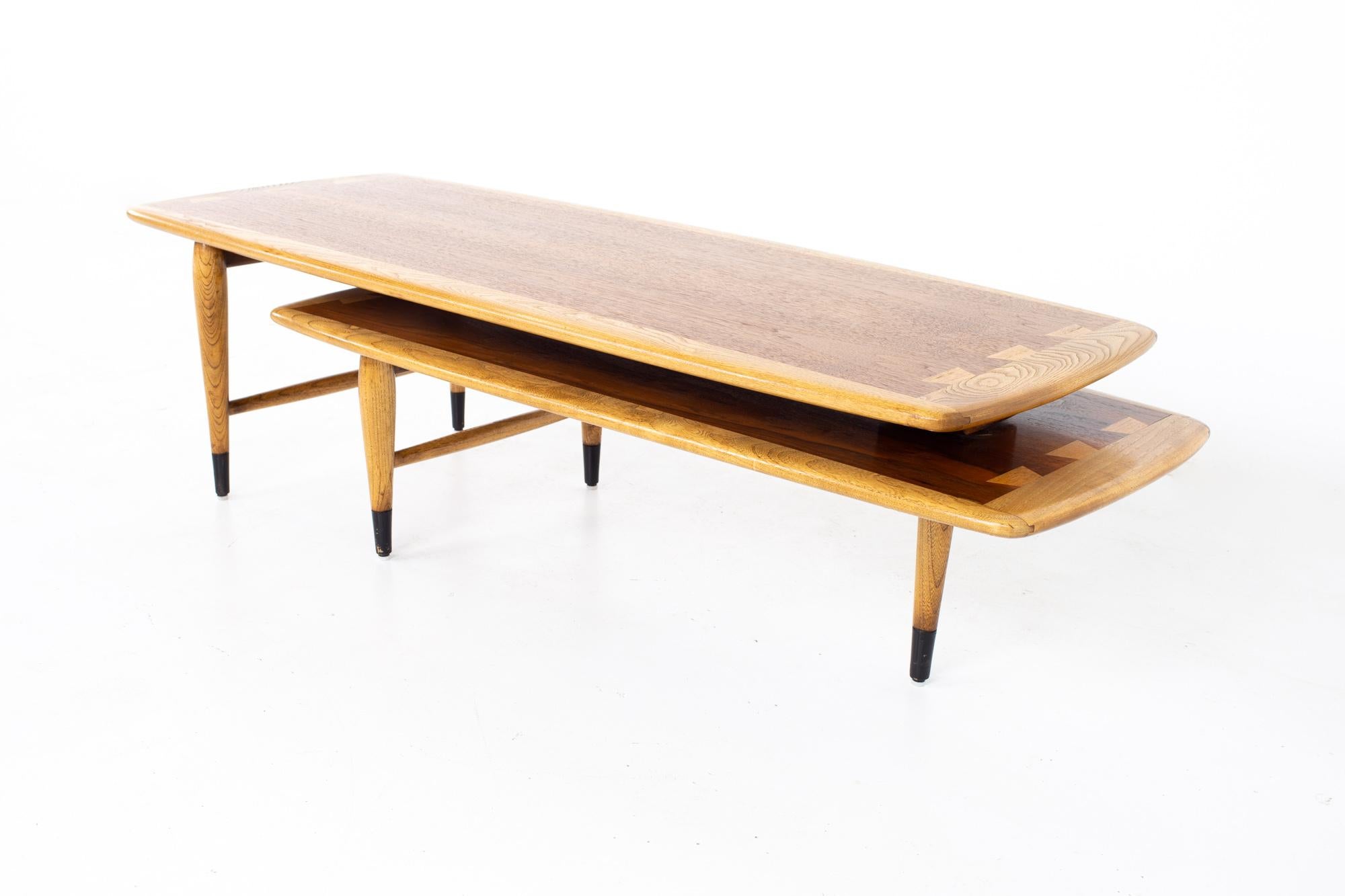 Andre Bus for Lane acclaim mid century walnut and oak dovetail switchblade coffee table
Table measures: 51.5 wide x 19.75 deep x 15 inches high

All pieces of furniture can be had in what we call restored vintage condition. That means the piece