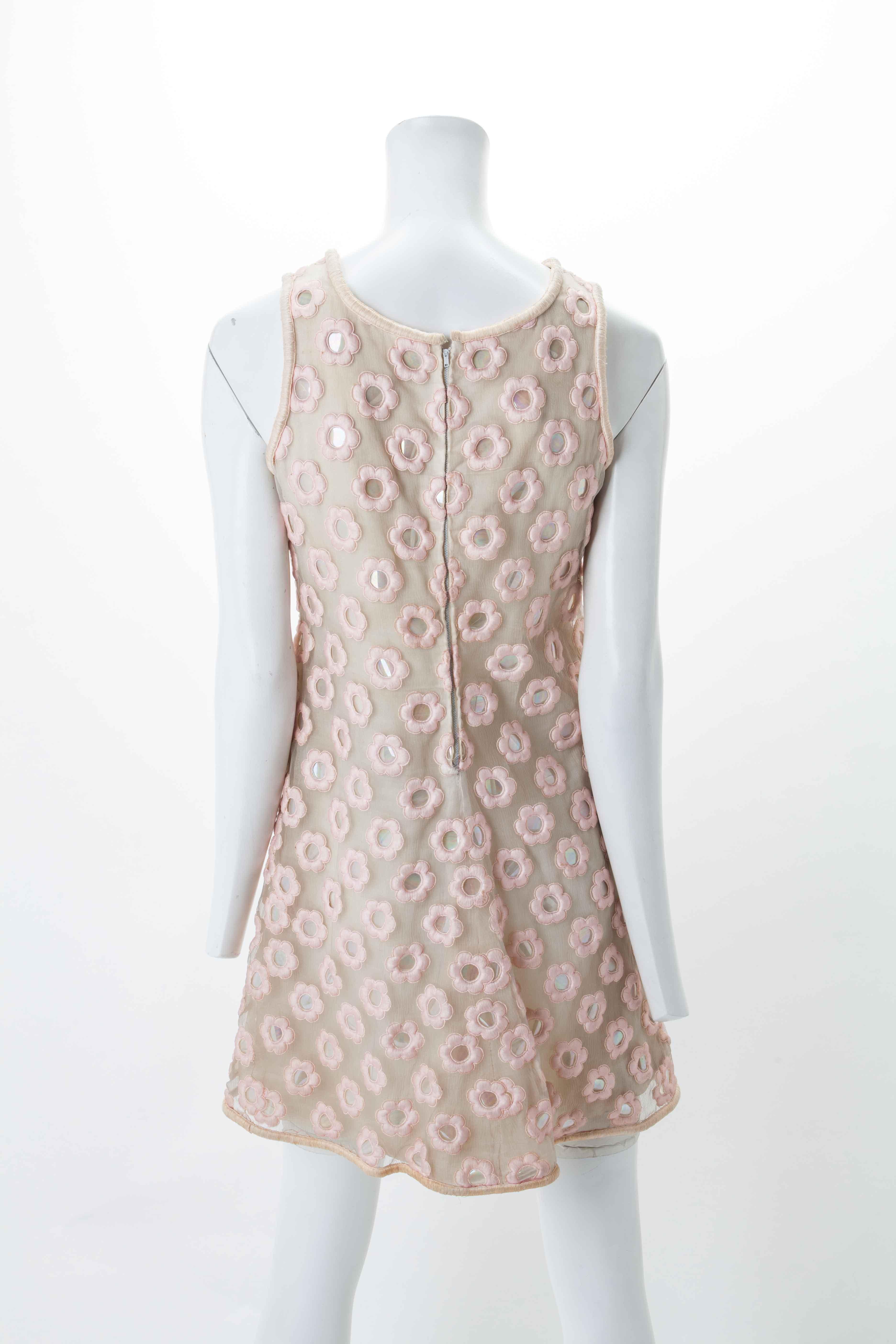 André Courrèges Custom made nude mini-dress with pink daisy motif, ca. 1970s
All-over appliqué A-Line mini dress w/ keyhole cutout above chest. Featuring scalloped petals worked in satin with pink organza overlays. The flowers' center are glimmering