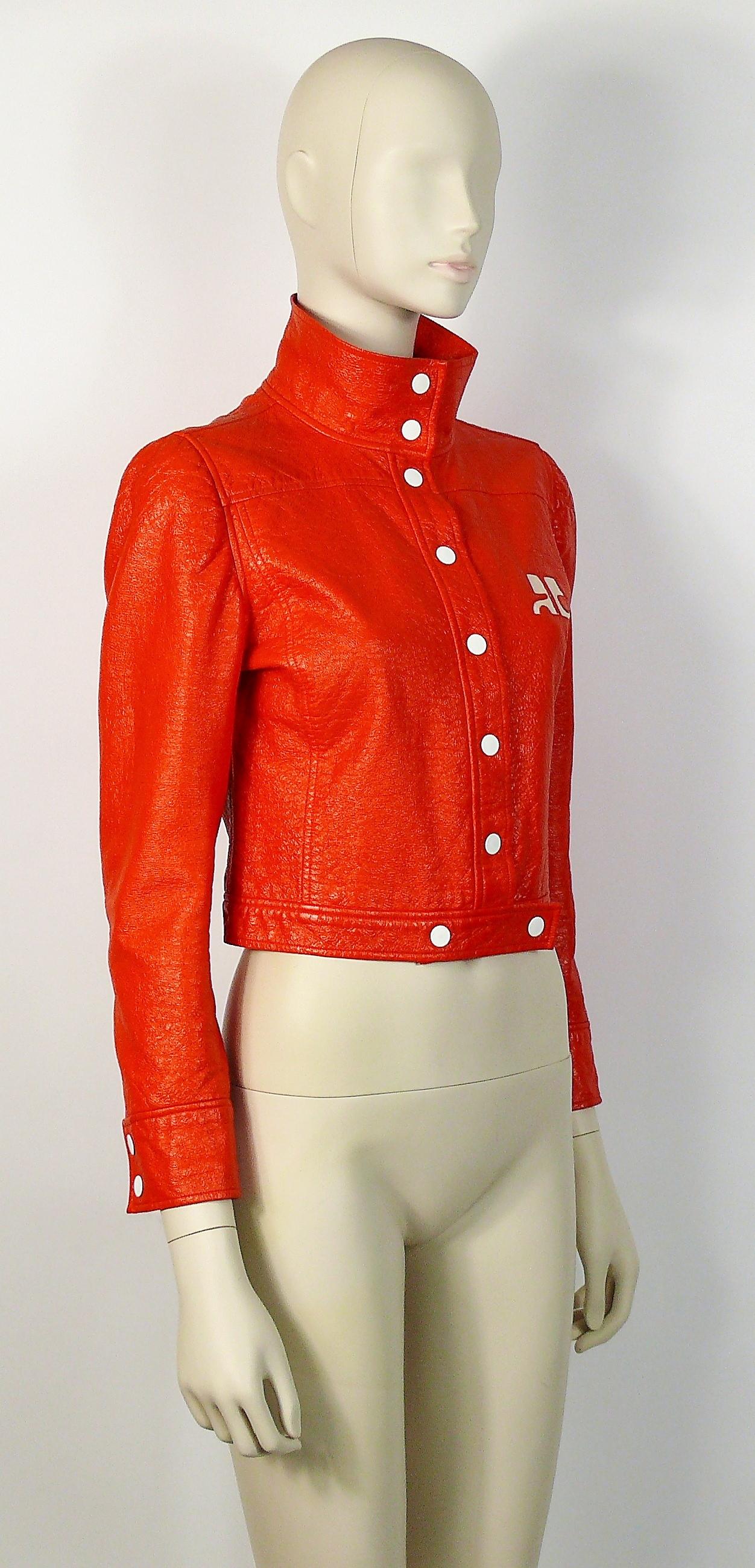 ANDRE COURREGES vintage orange vinyl jacket featuring a front signature logo.

This jacket features :
- Iconic COURREGE orange color vinyl.
- Cropped length.
- Stand collar.
- White metal snap buttons down the front, waist and cuffs.
- Fully lined